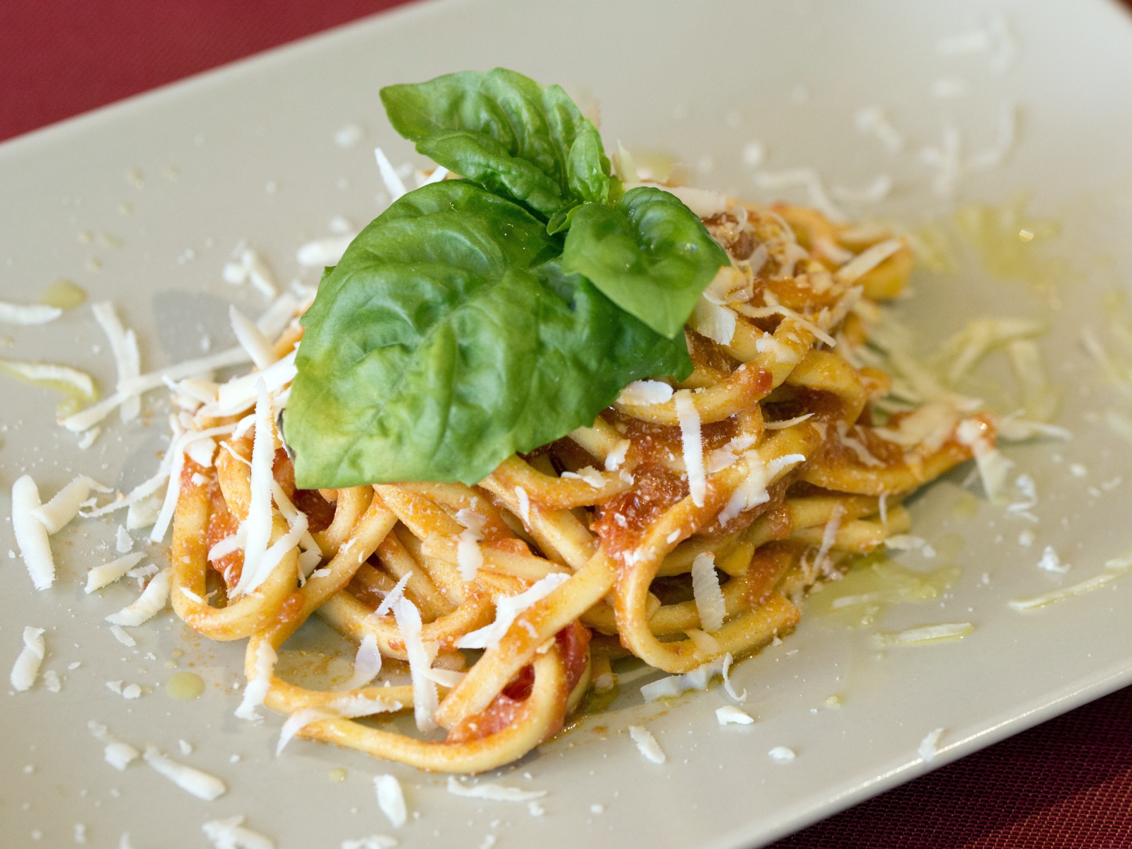 Spaghetti with cheese and basil leaves