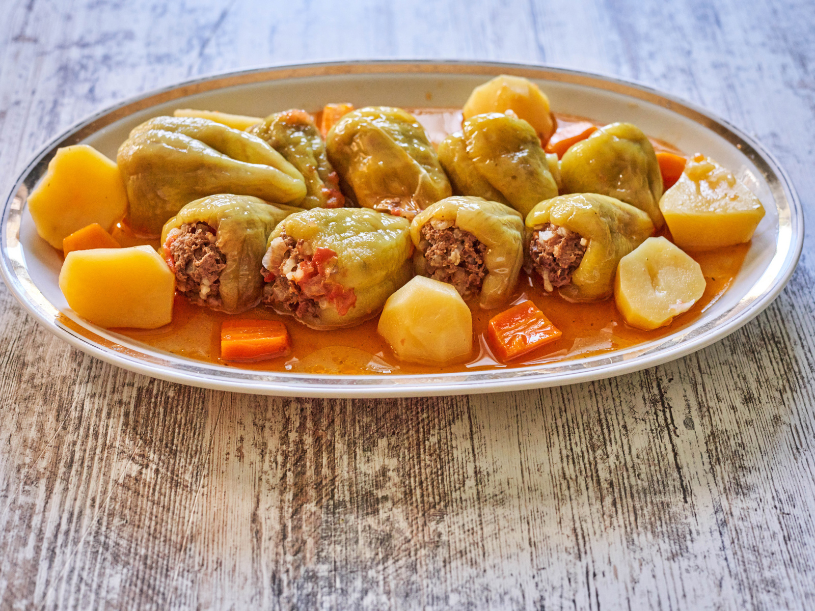 Фаршированный перец на тарелке с картофелем