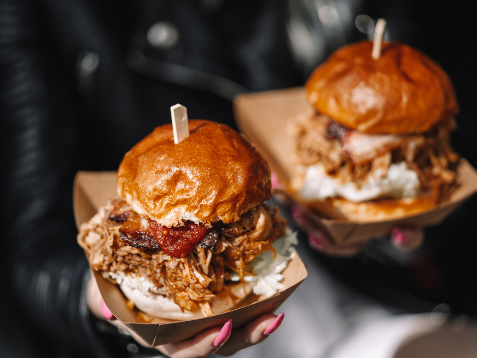 Два гамбургера в коробках в руках у девушки