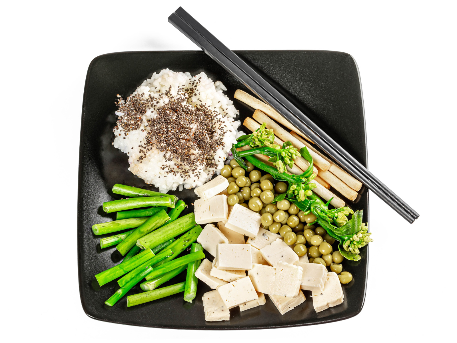 Овощи, сыр и рис на тарелке с палочками