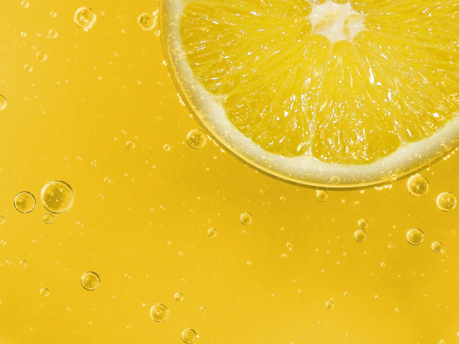 Лимон на желтом фоне с каплями воды