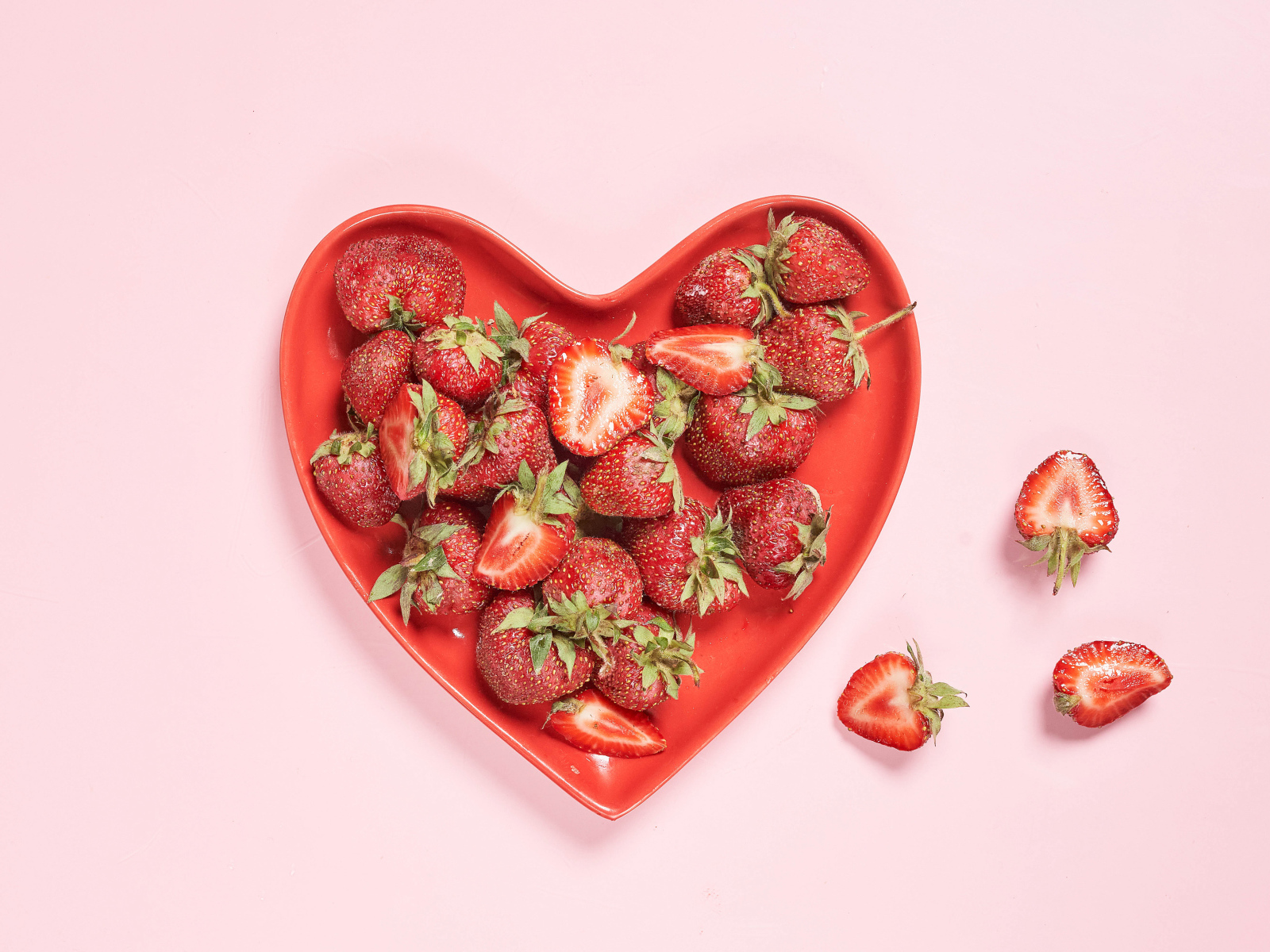 Красная тарелка в форме сердца с клубникой 