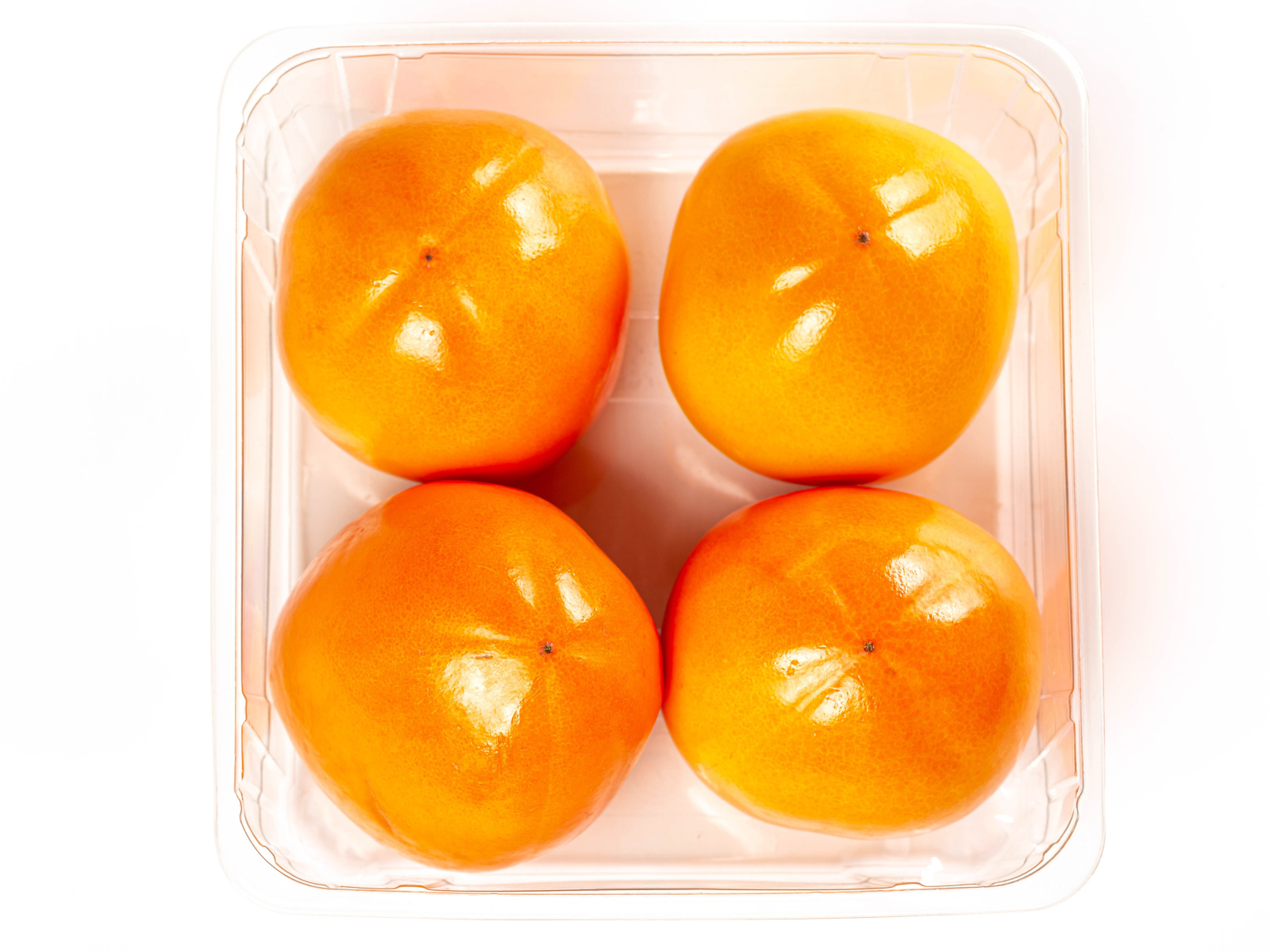 Спелая хурма с лотке на белом фоне