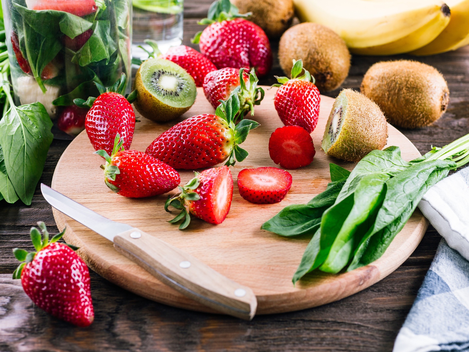 Нарезанная клубника и киви на деревянной доске 