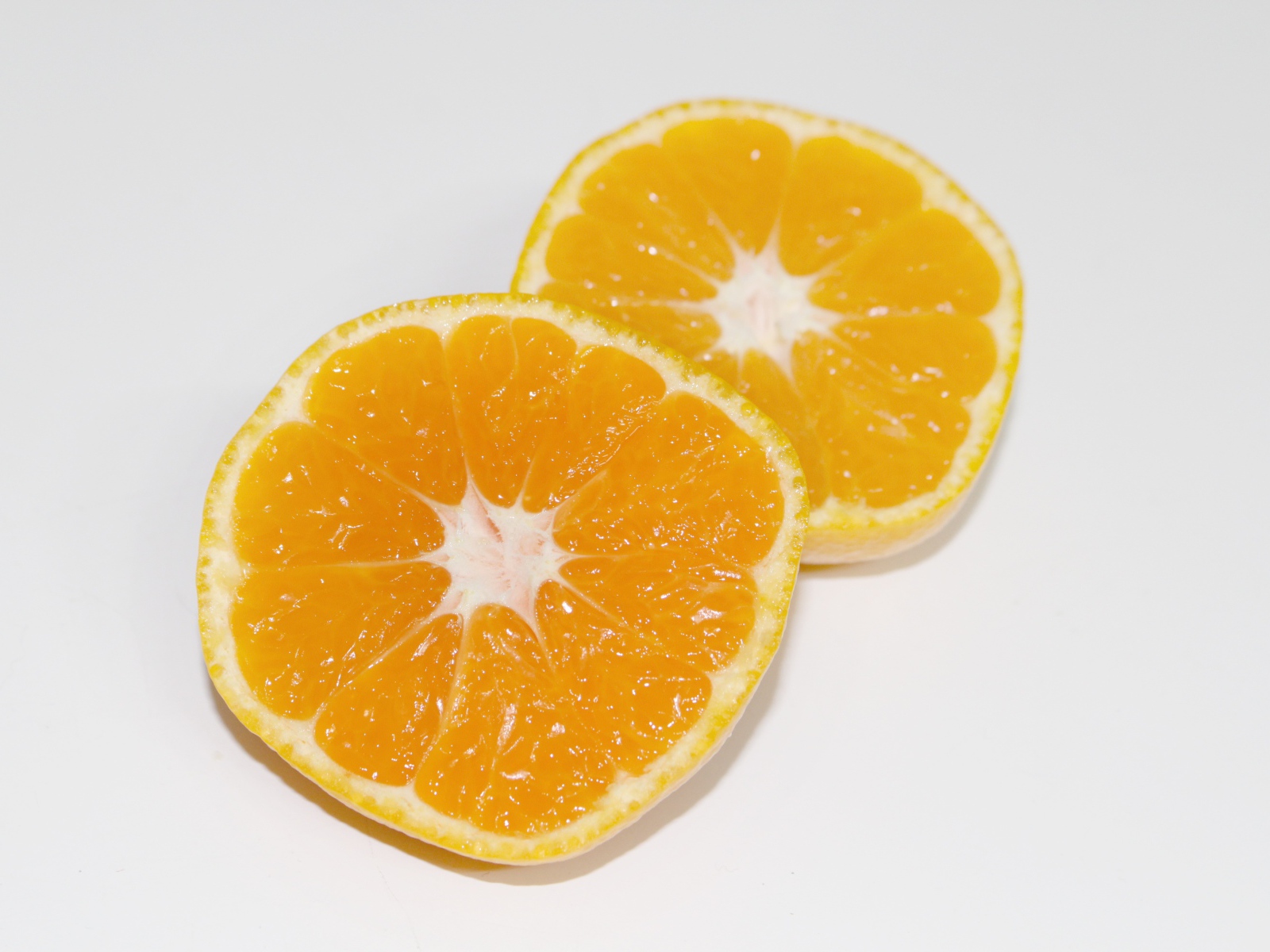 Два кружочка мандарина на сером столе 