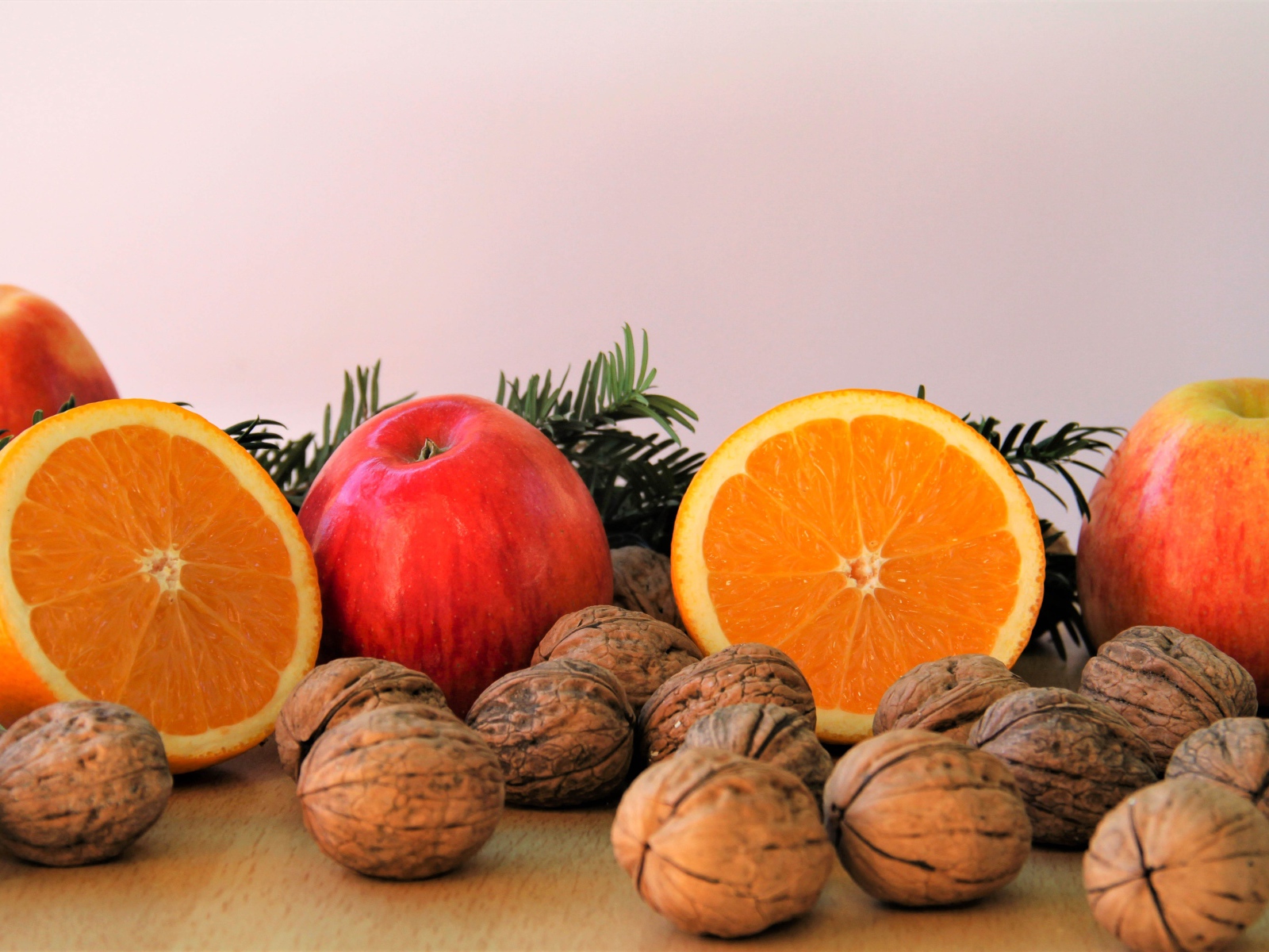 Грецкие орехи с апельсинами и яблоками на столе