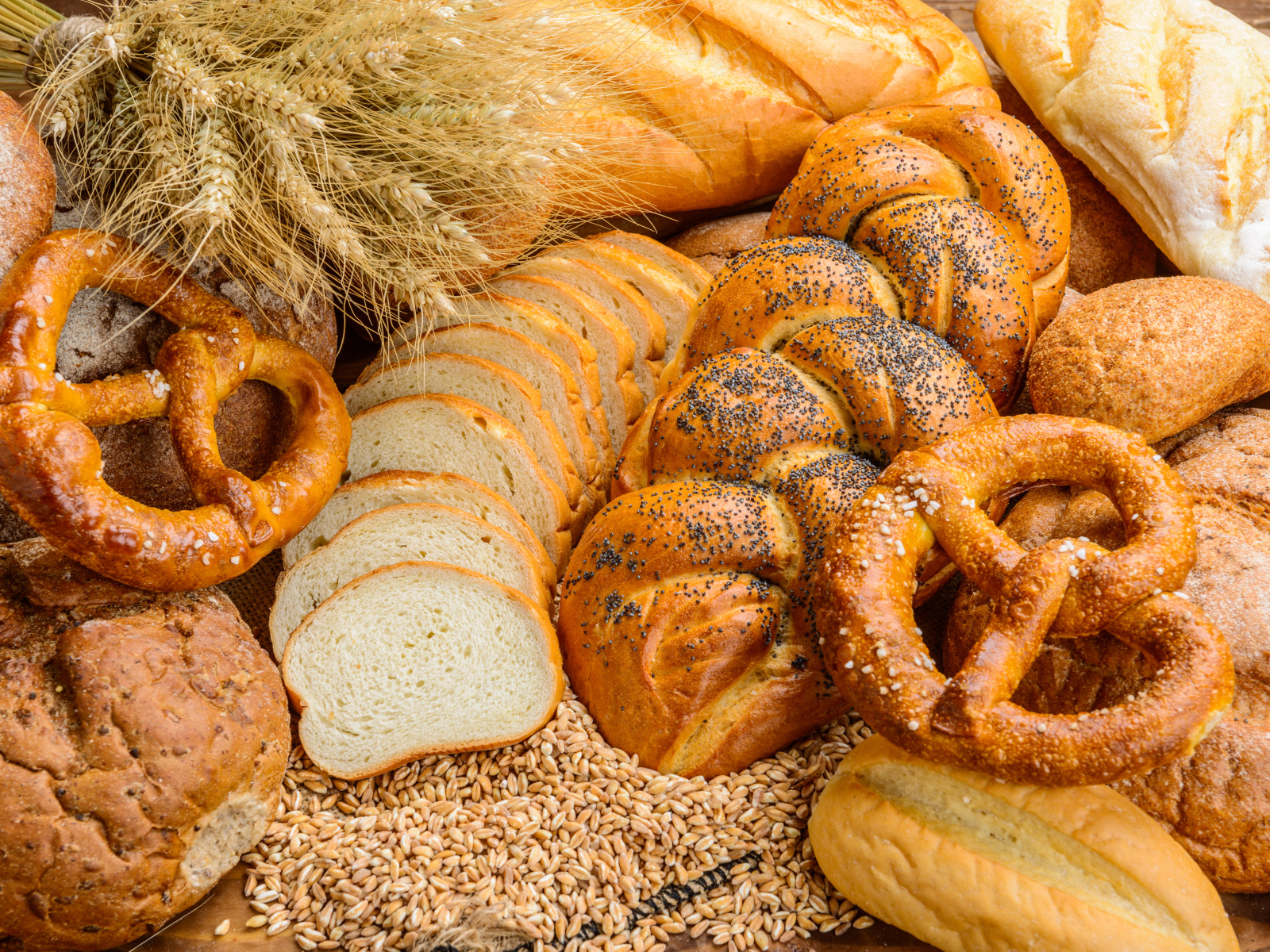 Свежая выпечка на столе с колосьями и зернами пшеницы 