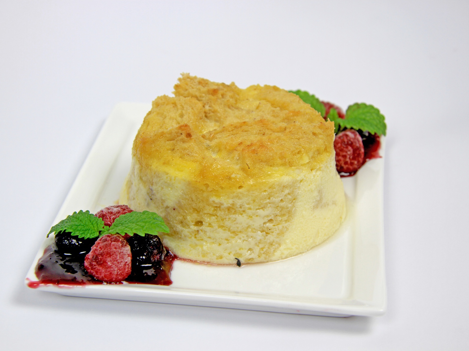 Пирожное на большой белой тарелке с ягодами