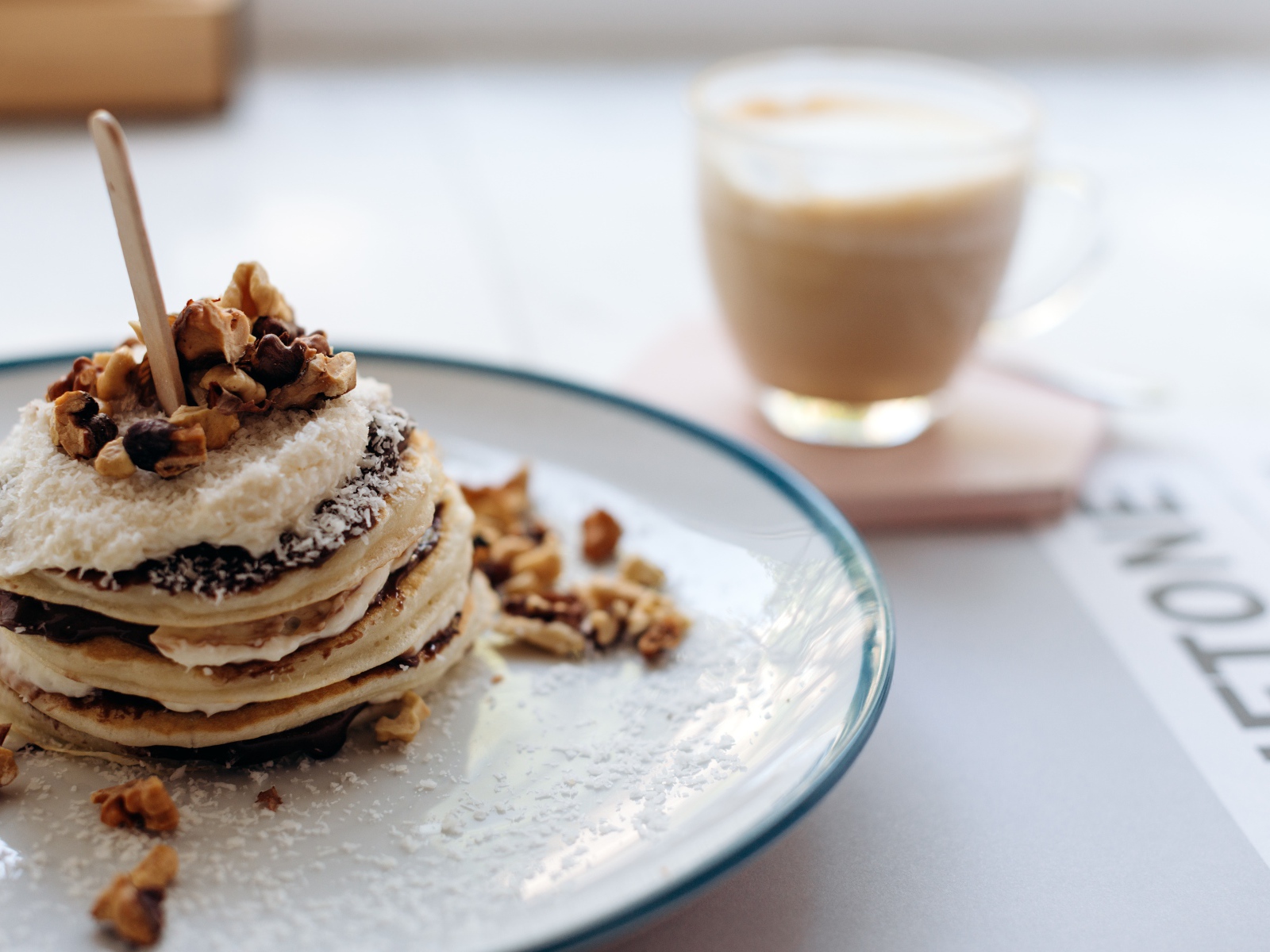 Жареные оладьи со сметаной на тарелке с грецкими орехами 