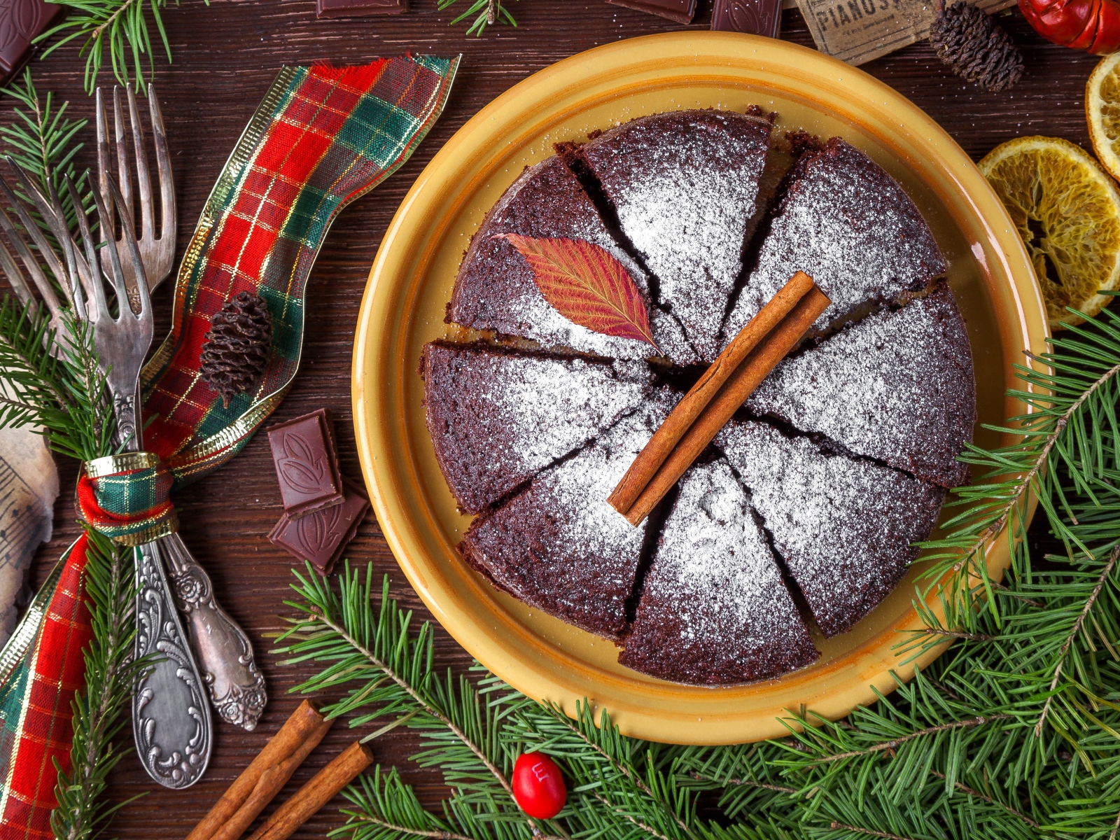 Пирог с сахарной пудрой на столе со столовыми приборами