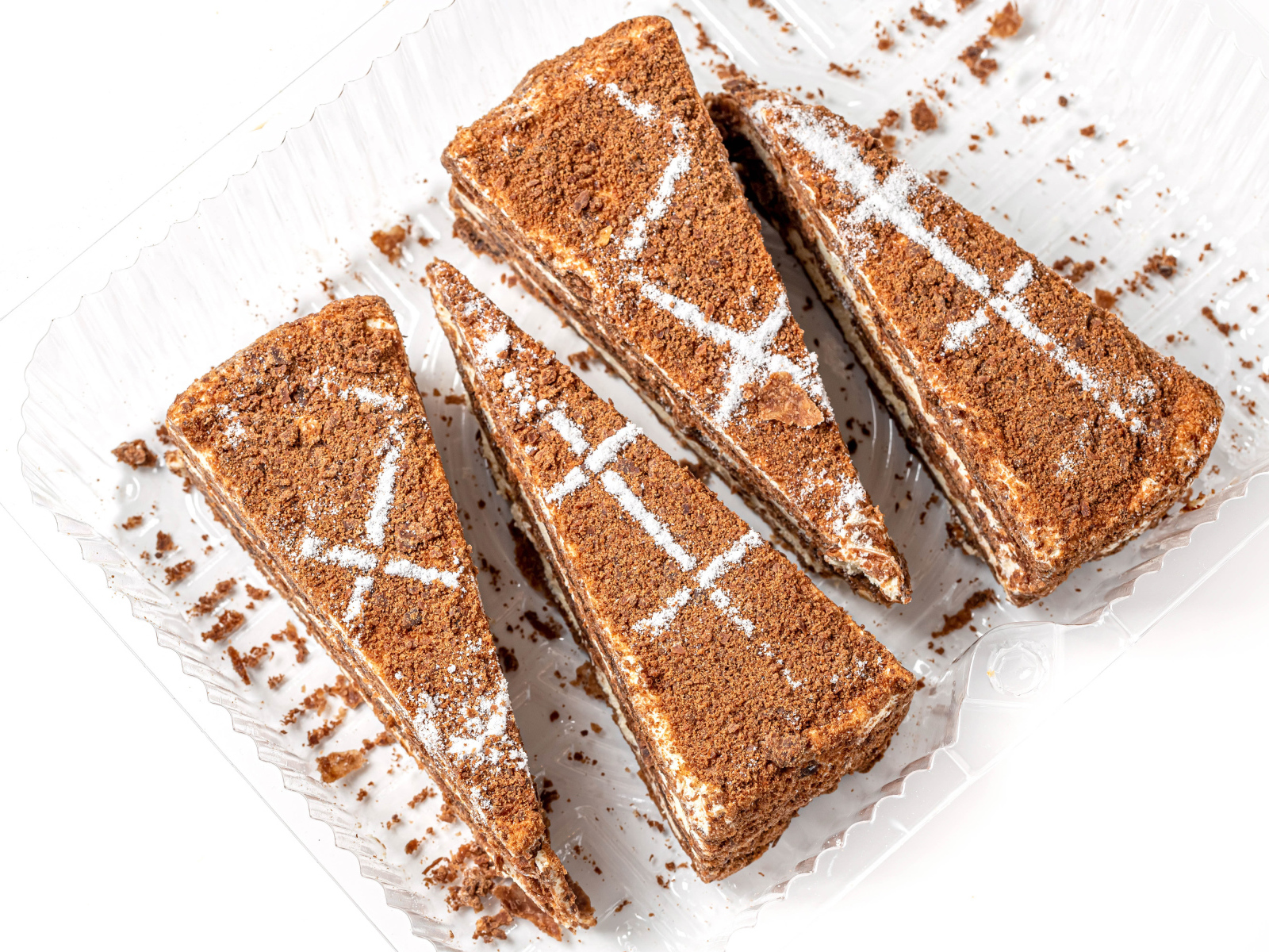 Куски аппетитного медового торта на белом фоне