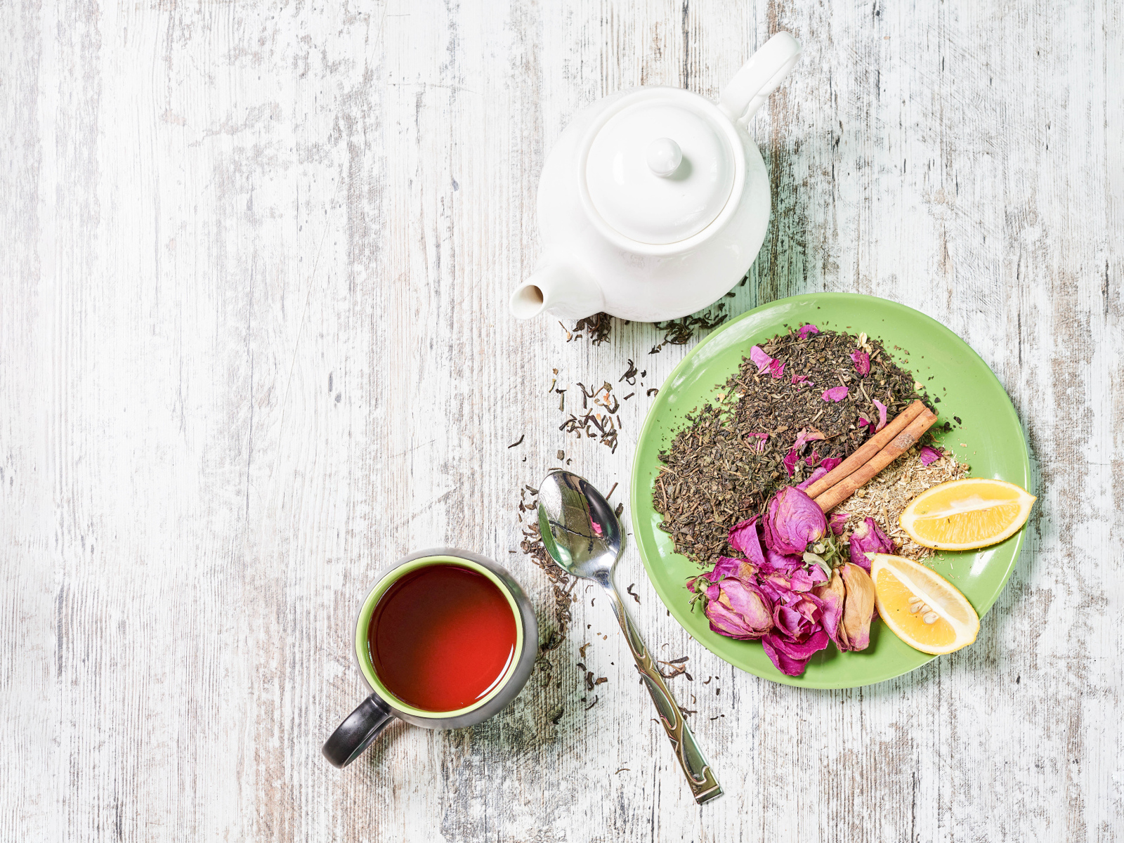 Чай на тарелке с кусочками лимона на столе