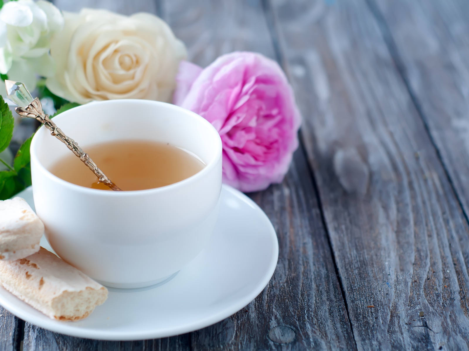 Белая чашка чая на деревянном  столе с розами