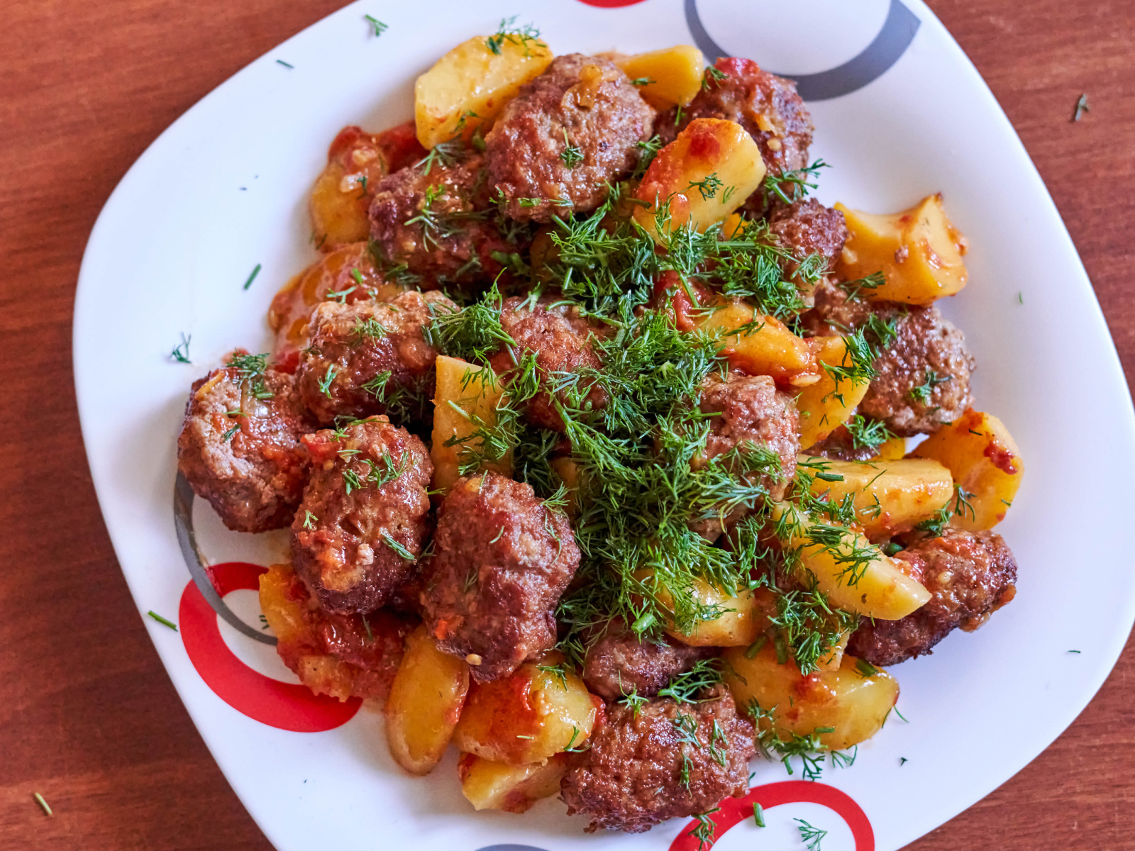 Фрикадельки с картофелем и укропом на белой тарелке