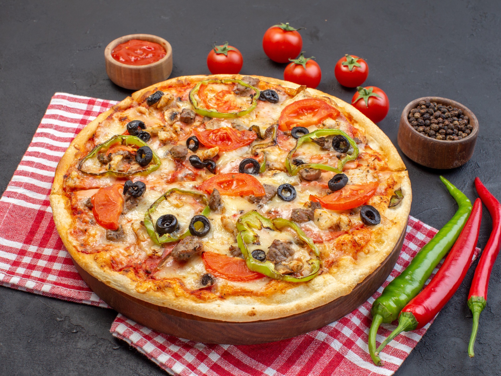 Большая ароматная пицца с помидорами и перцем на сером столе 