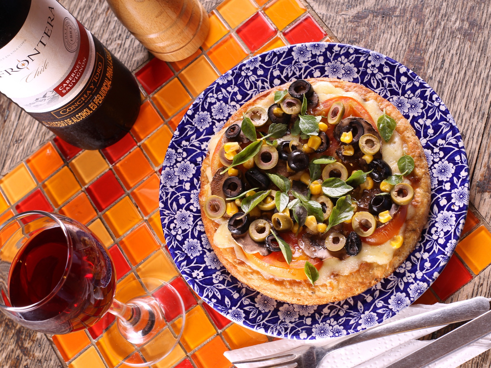 Итальянская пицца с оливками на столе с вином