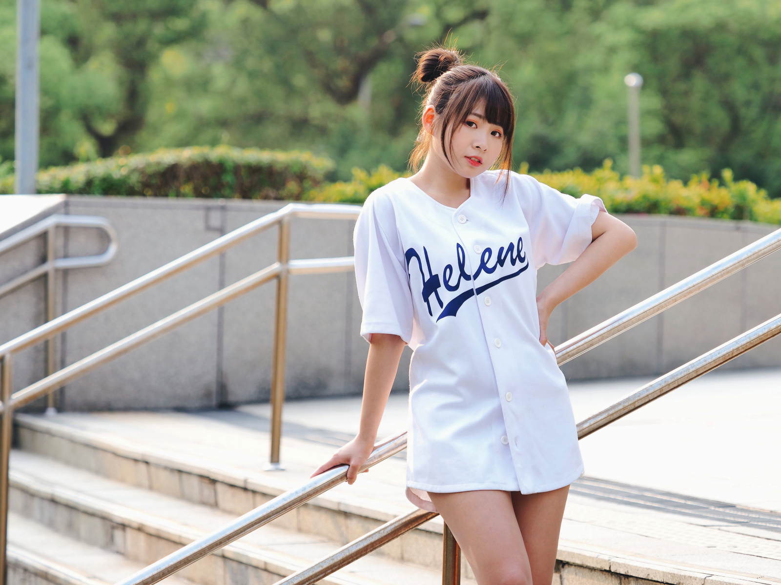 Красивая девушка азиатка в белой рубашке на ступенях 