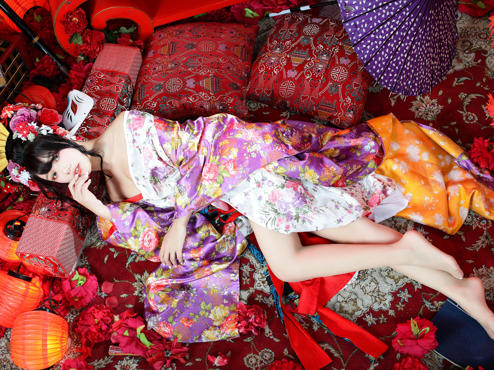 Красивая девушка азиатка в кимоно лежит на полу