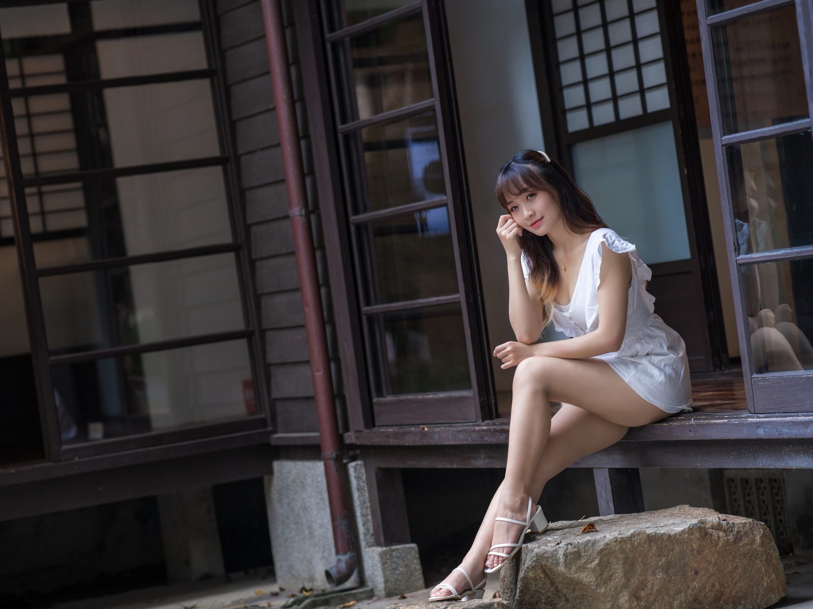 Красивая девушка азиатка сидит у двери