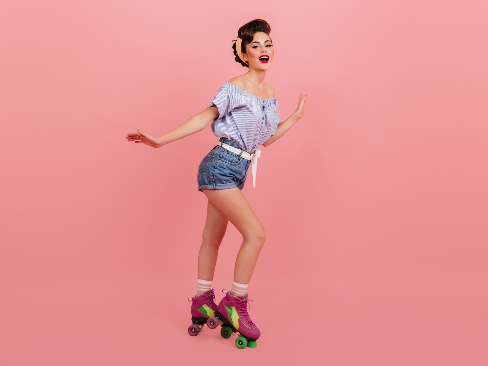 Красивая девушка на роликах на розовом фоне 