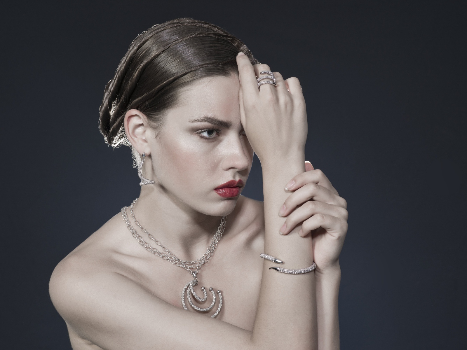 Красивая девушка с украшениями на теле на сером фоне