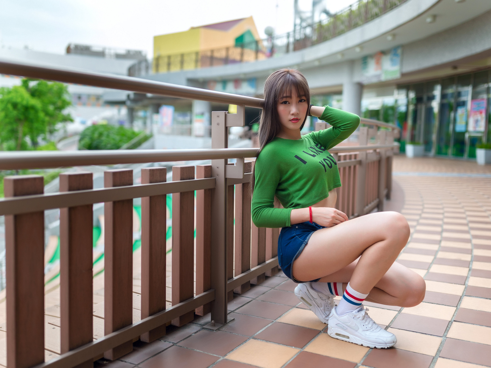 Красивая молодая азиатка в белых кроссовках 