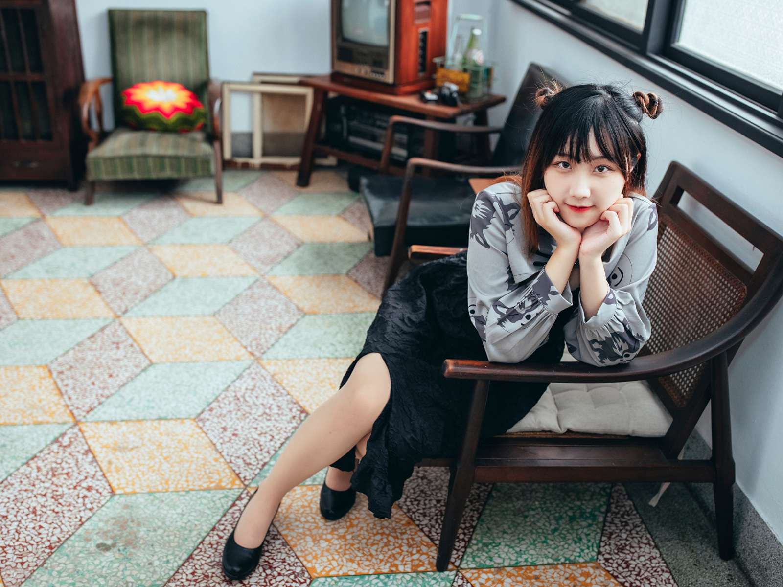 Красивая молодая азиатка сидит в кресле