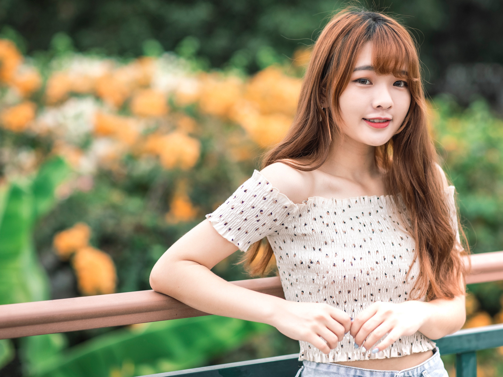 Милая девушка азиатка стоит у перил