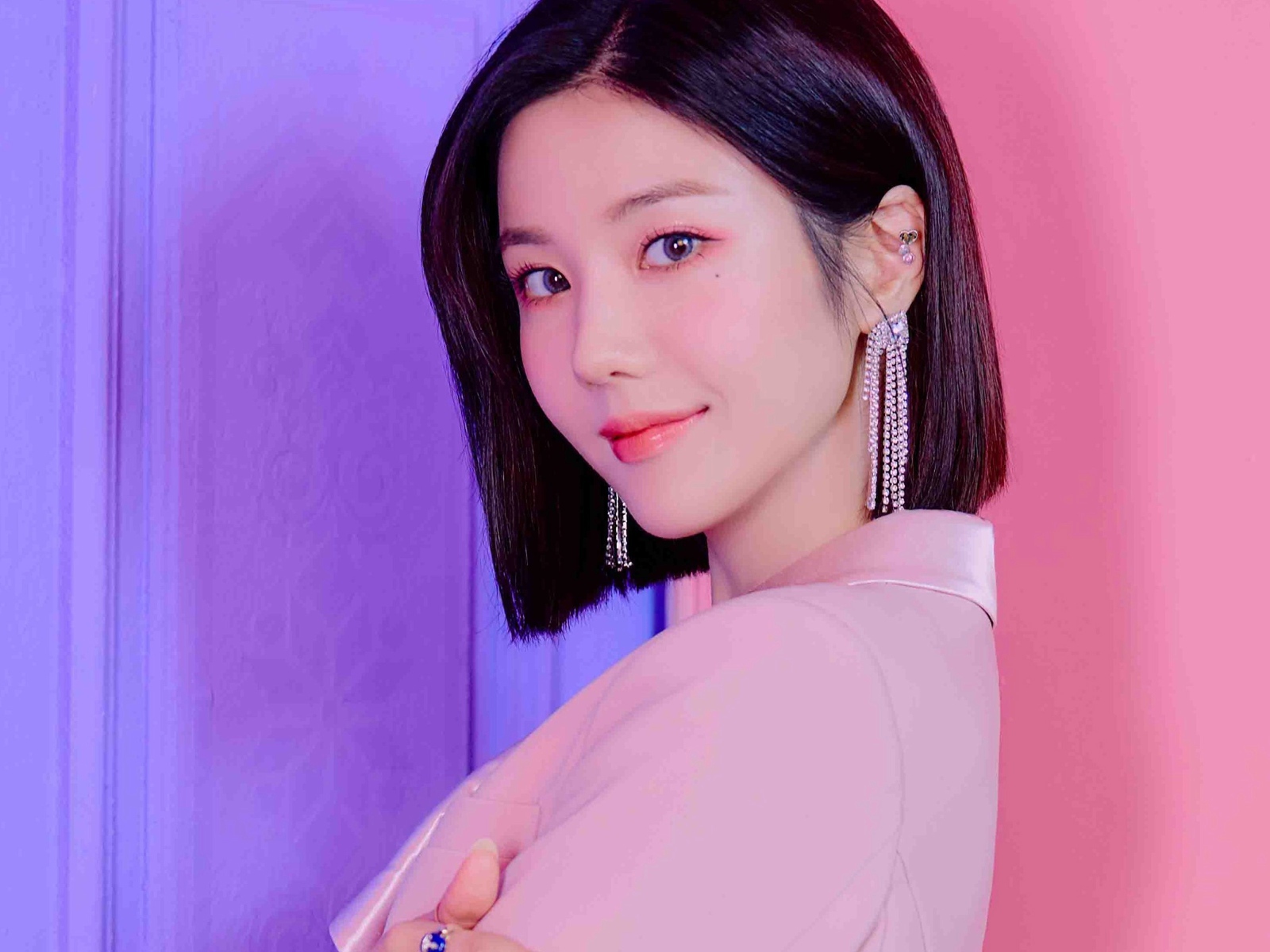 Милая девушка азиатка с короткой стрижкой на розовом фоне 