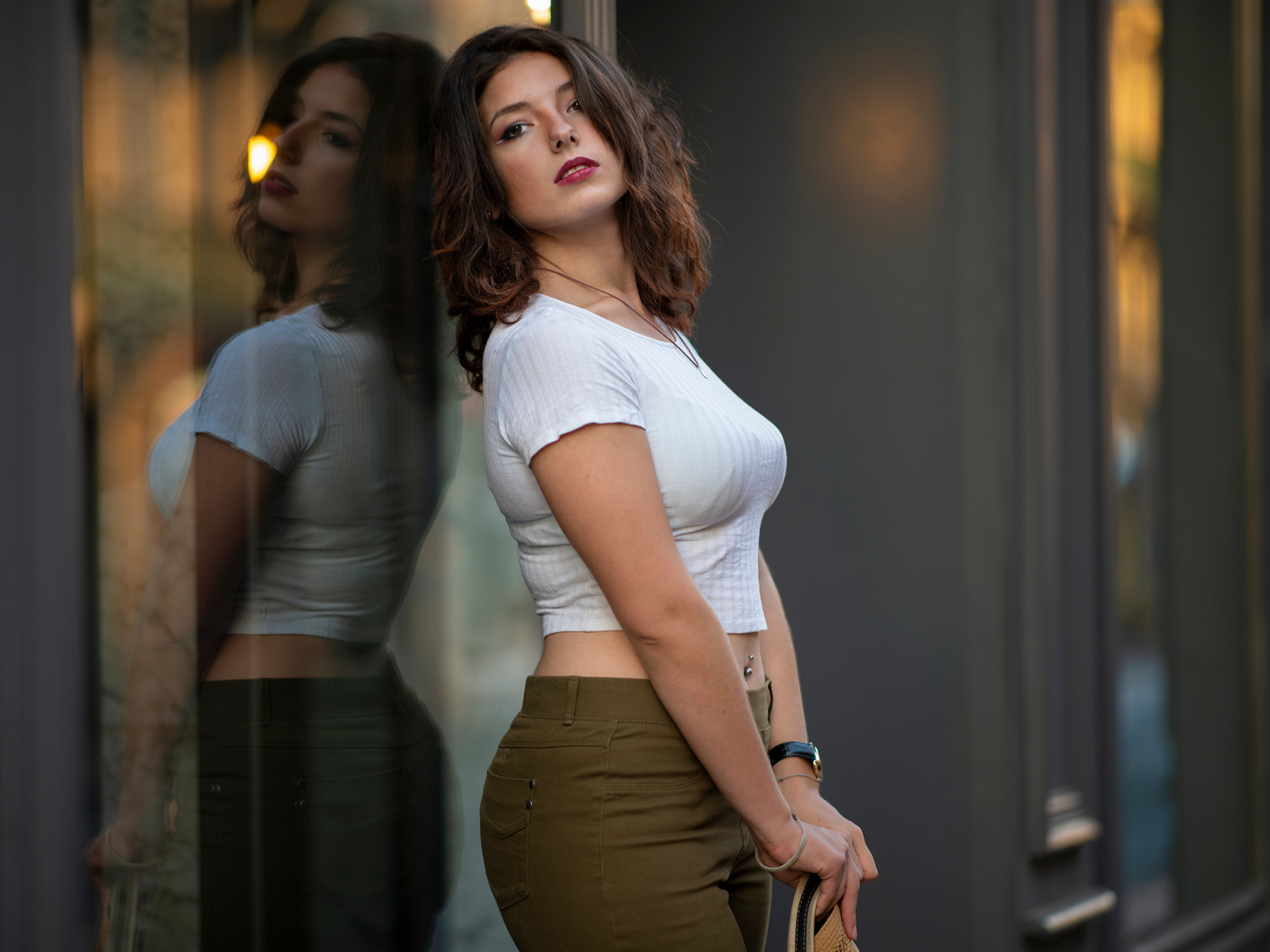 Милая девушка стоит у стеклянной двери 