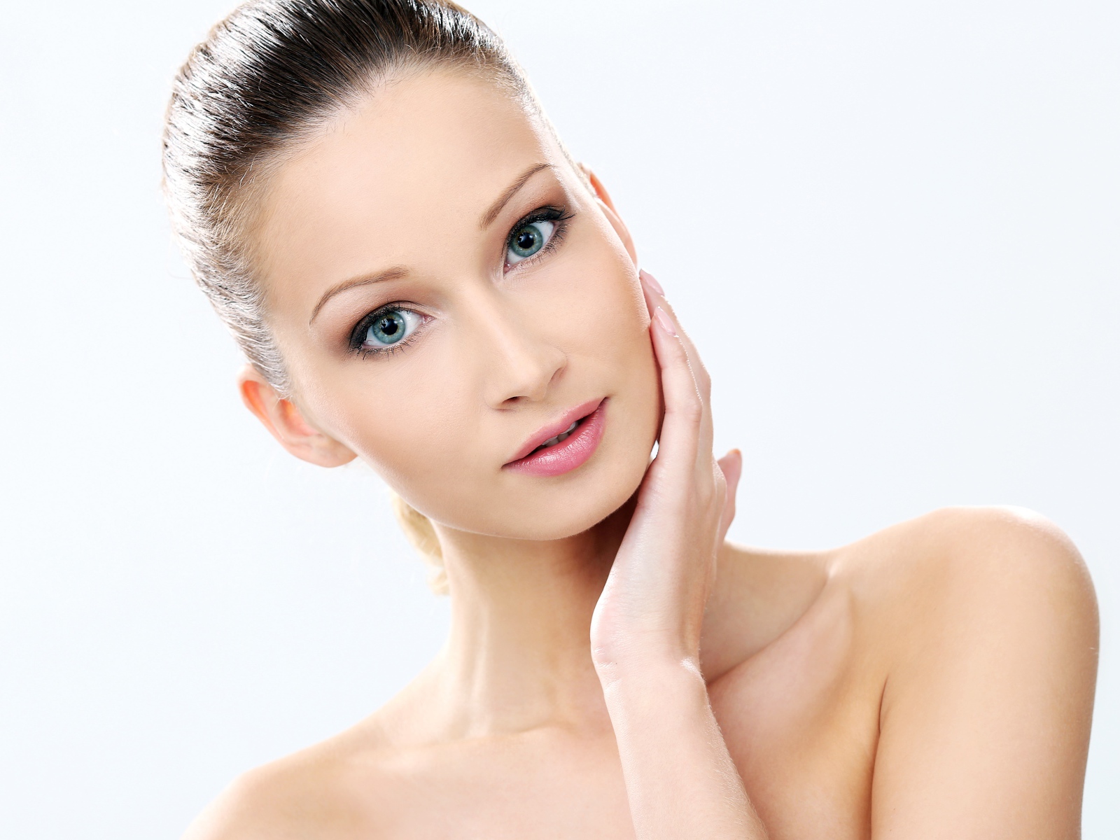Нежная голубоглазая девушка без макияжа на белом фоне