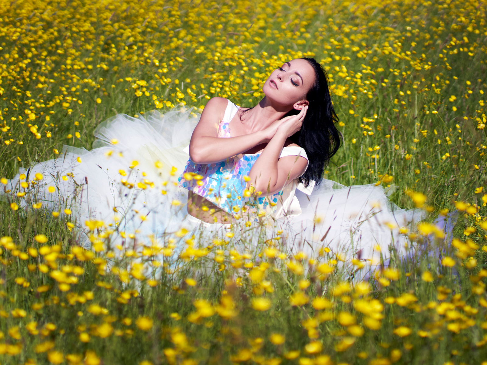 Девушка в красивом платье на траве с желтыми цветами