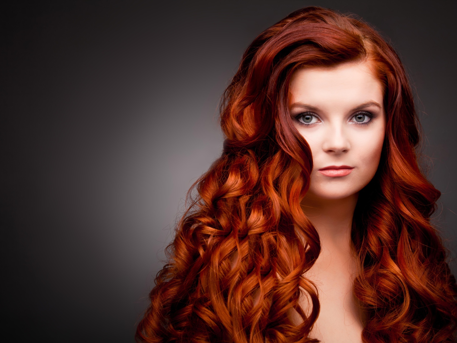 Длинные ярко рыжие волосы у красивой девушки 