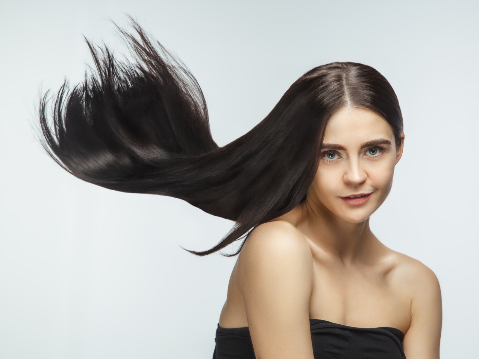 Длинные шелковистые волосы молодой брюнетки 