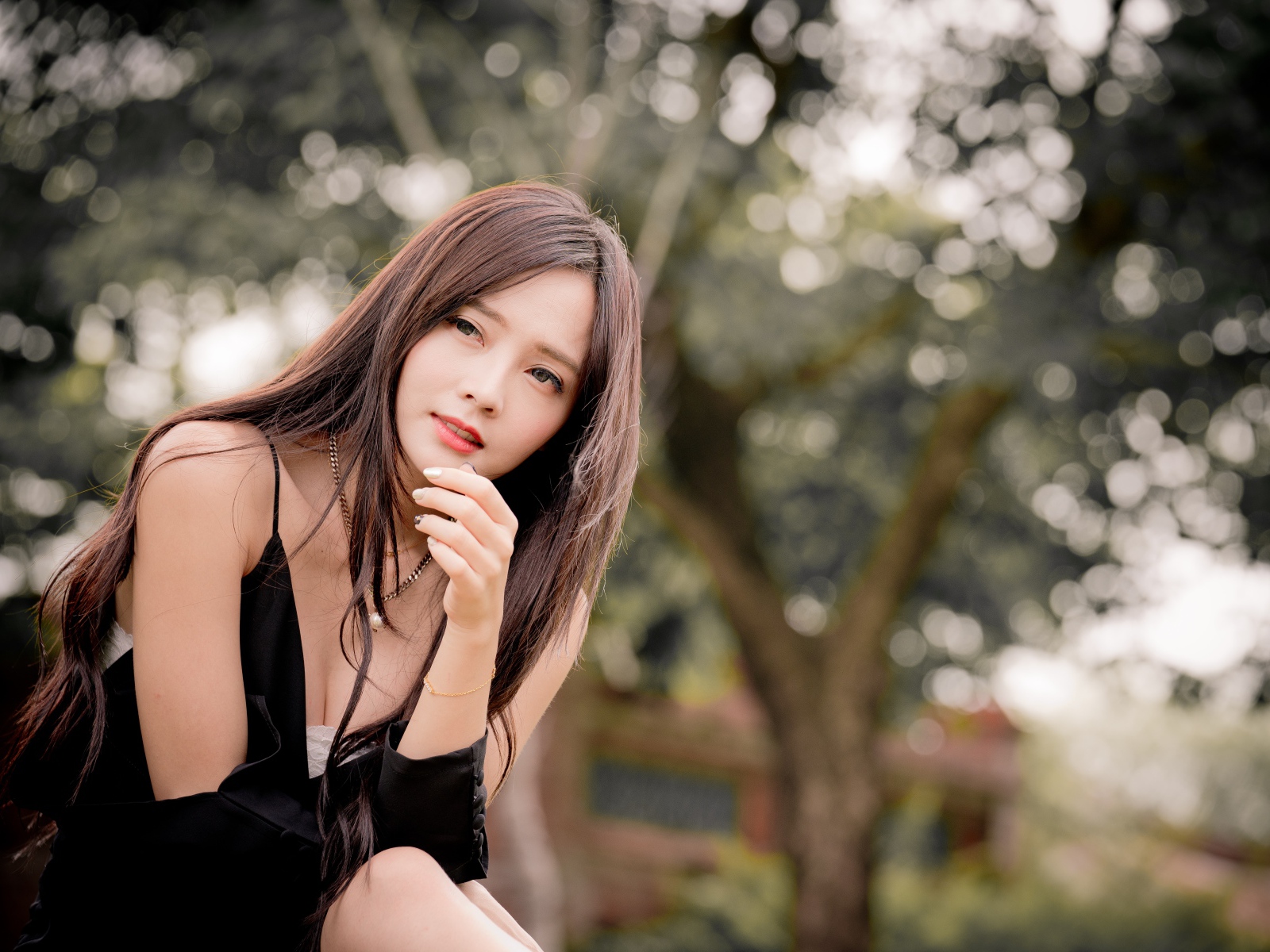 Задумчивая девушка азиатка в черном платье 