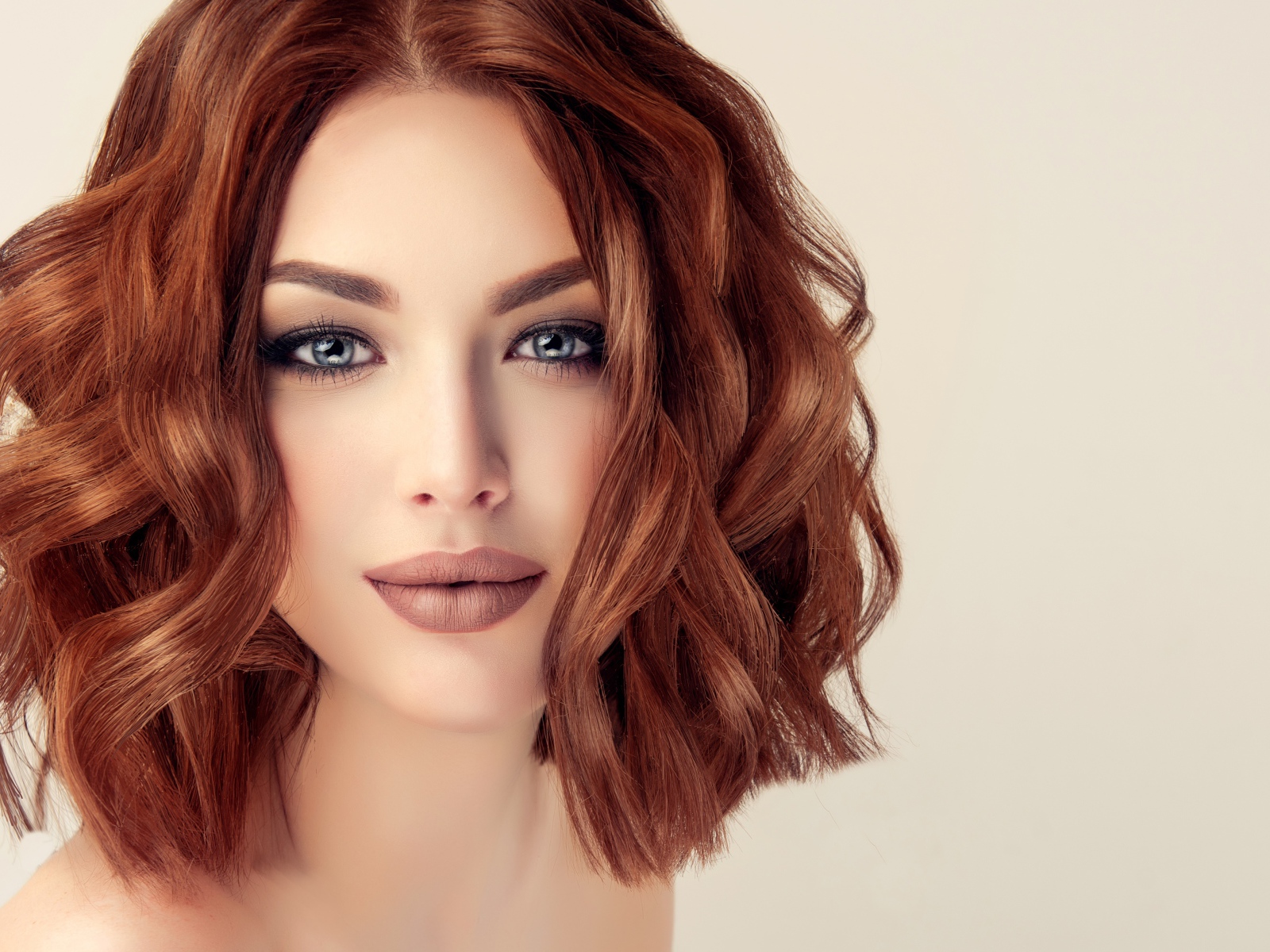 Рыжеволосая голубоглазая девушка на сером фоне