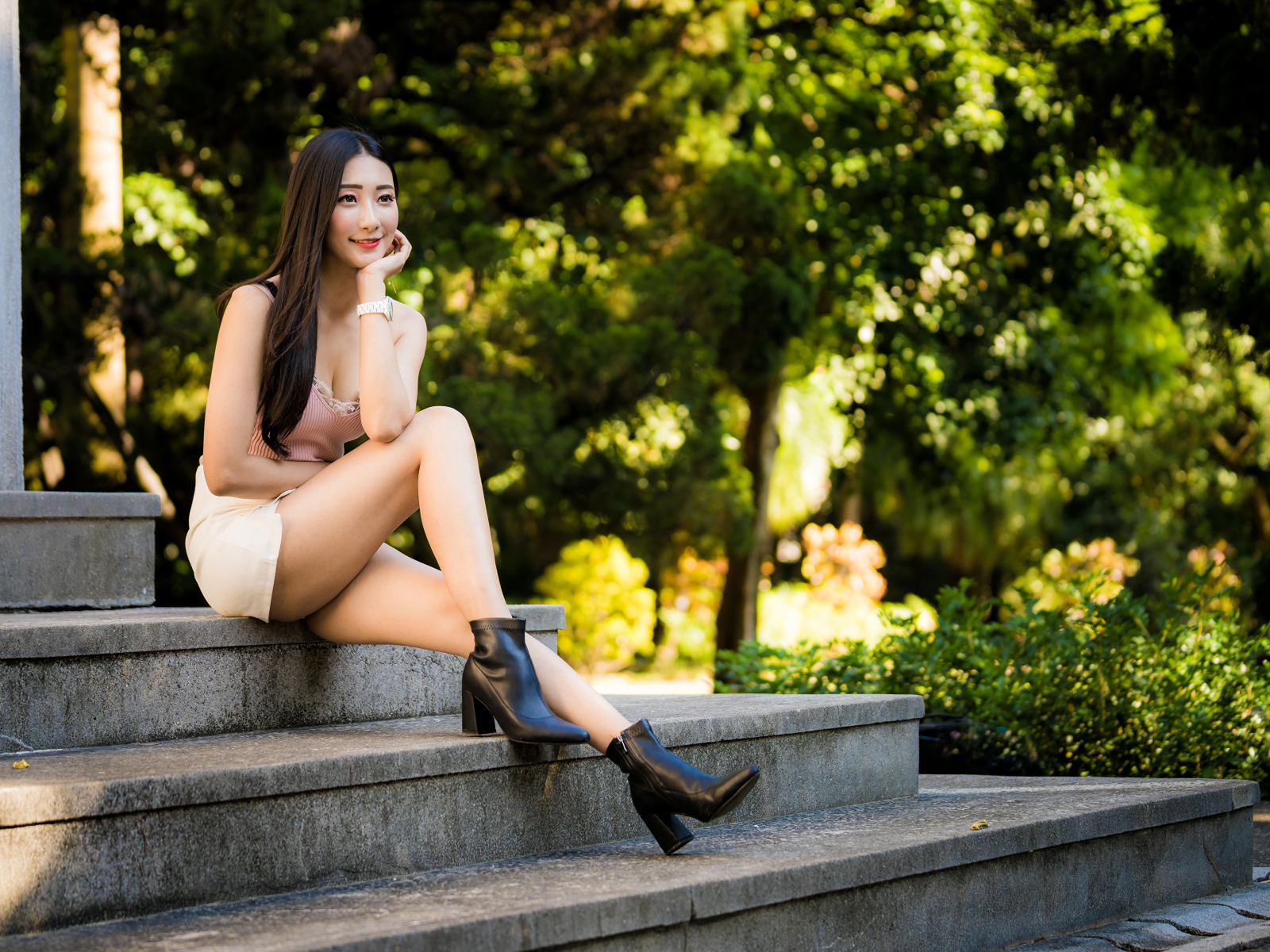 Улыбающаяся азиатка сидит на ступеньках