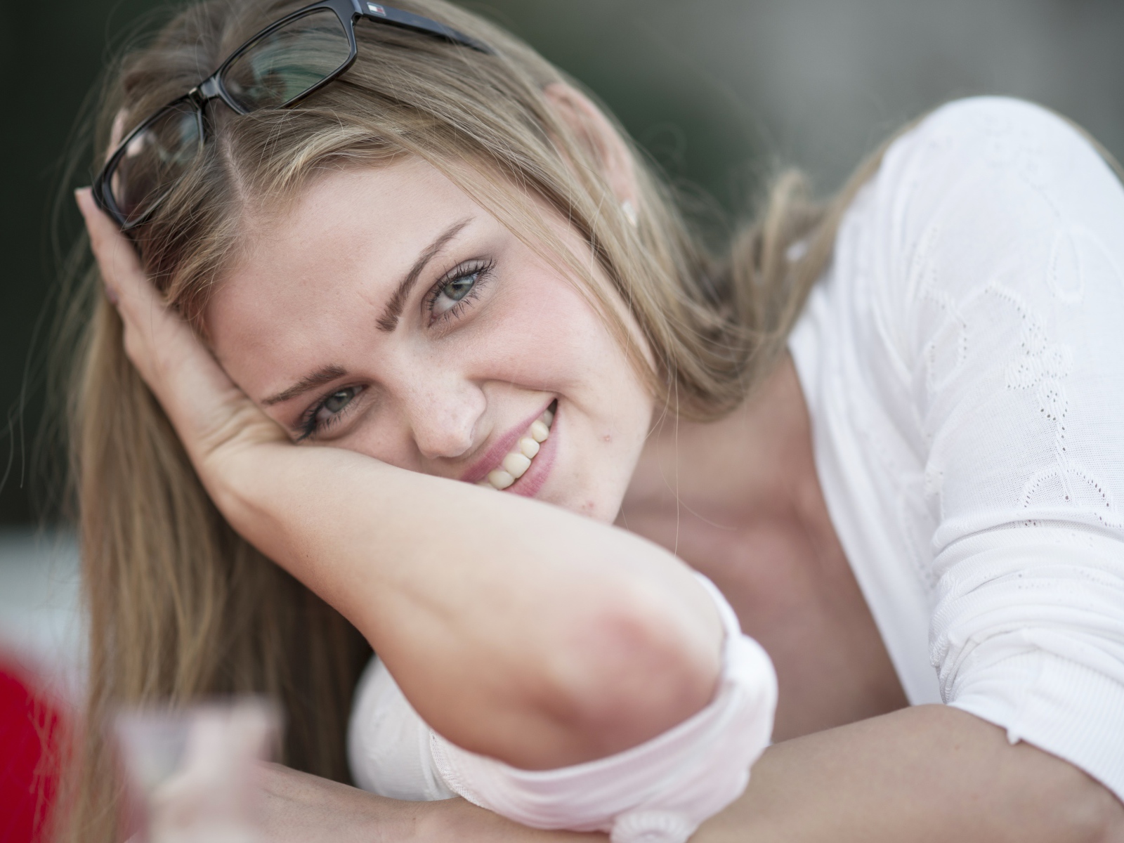 Улыбающаяся девушка блондинка с очками на голове