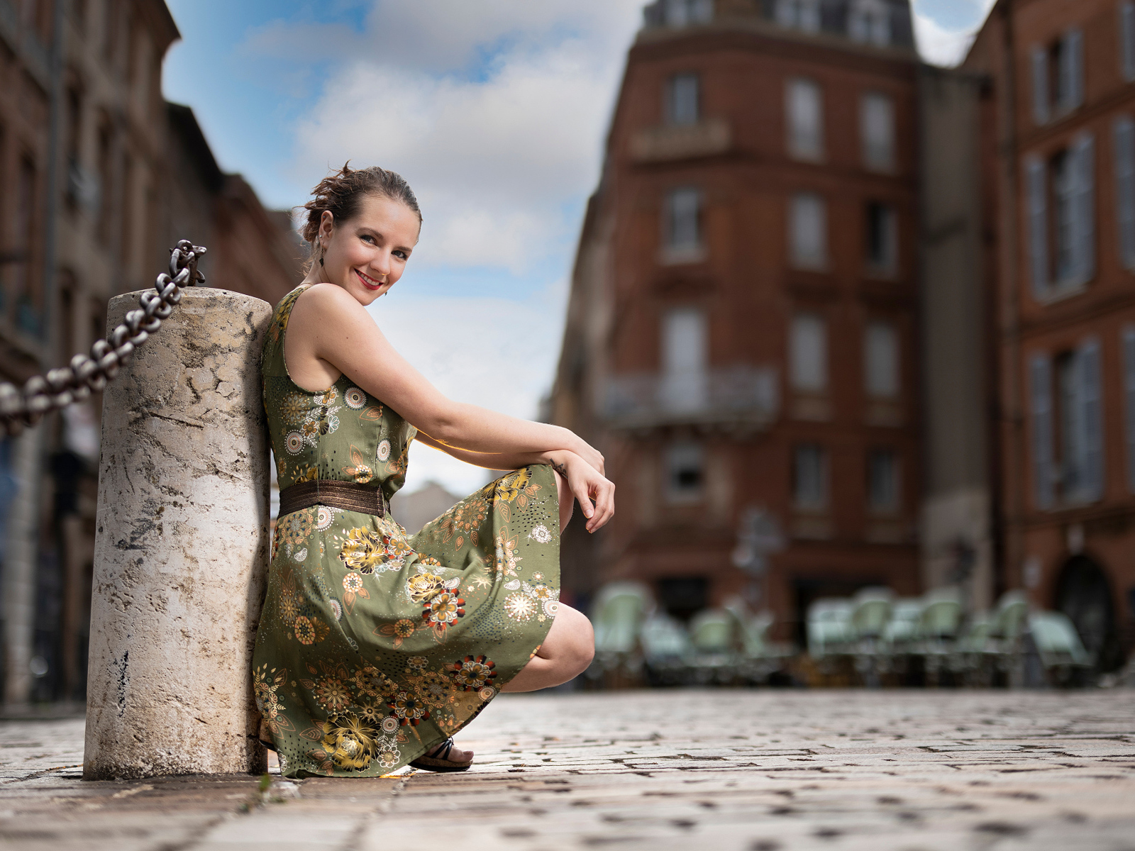 Улыбающаяся девушка в платье на улице города