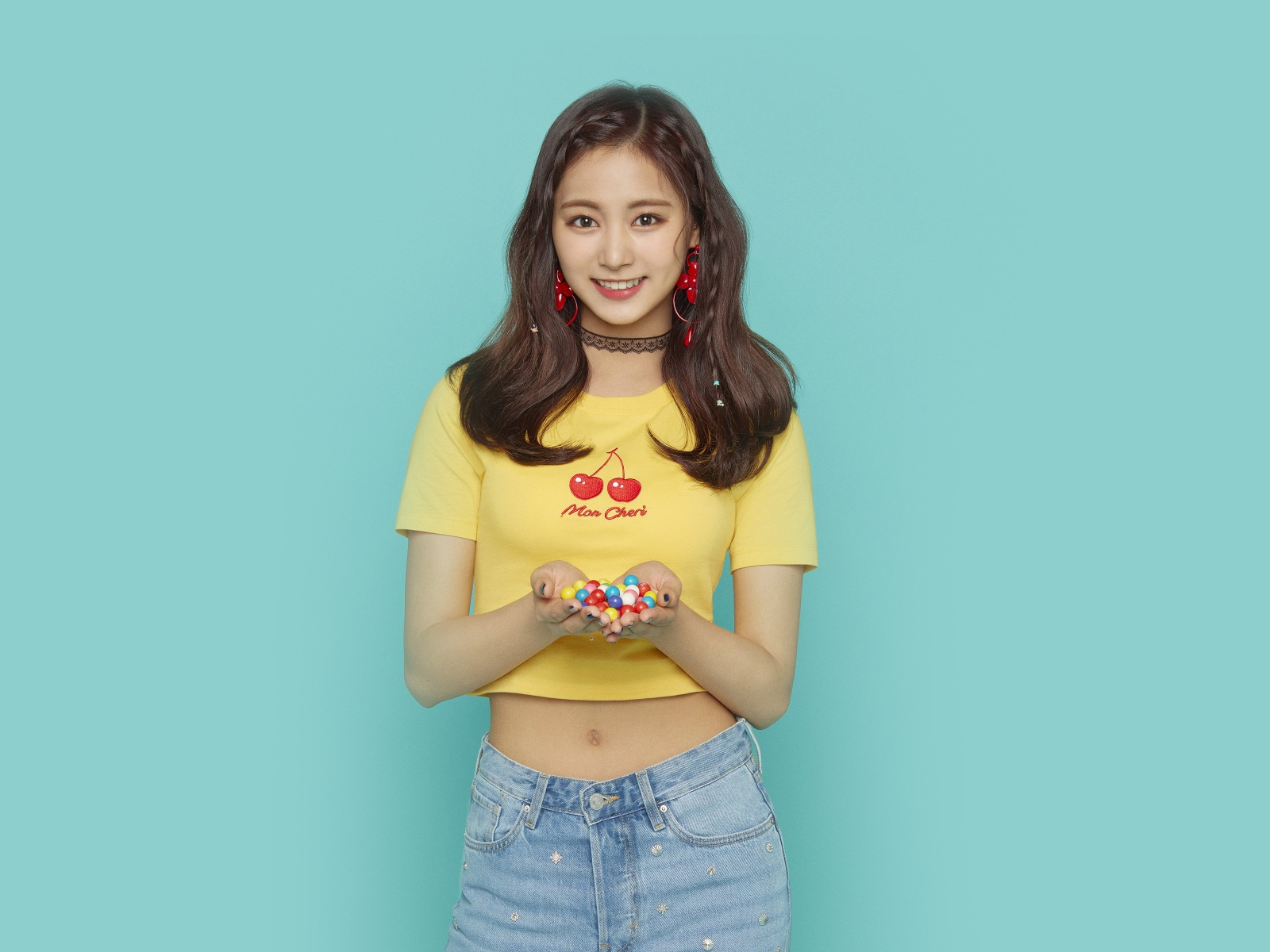 Улыбающаяся девушка с конфетами в ладонях на голубом фоне 