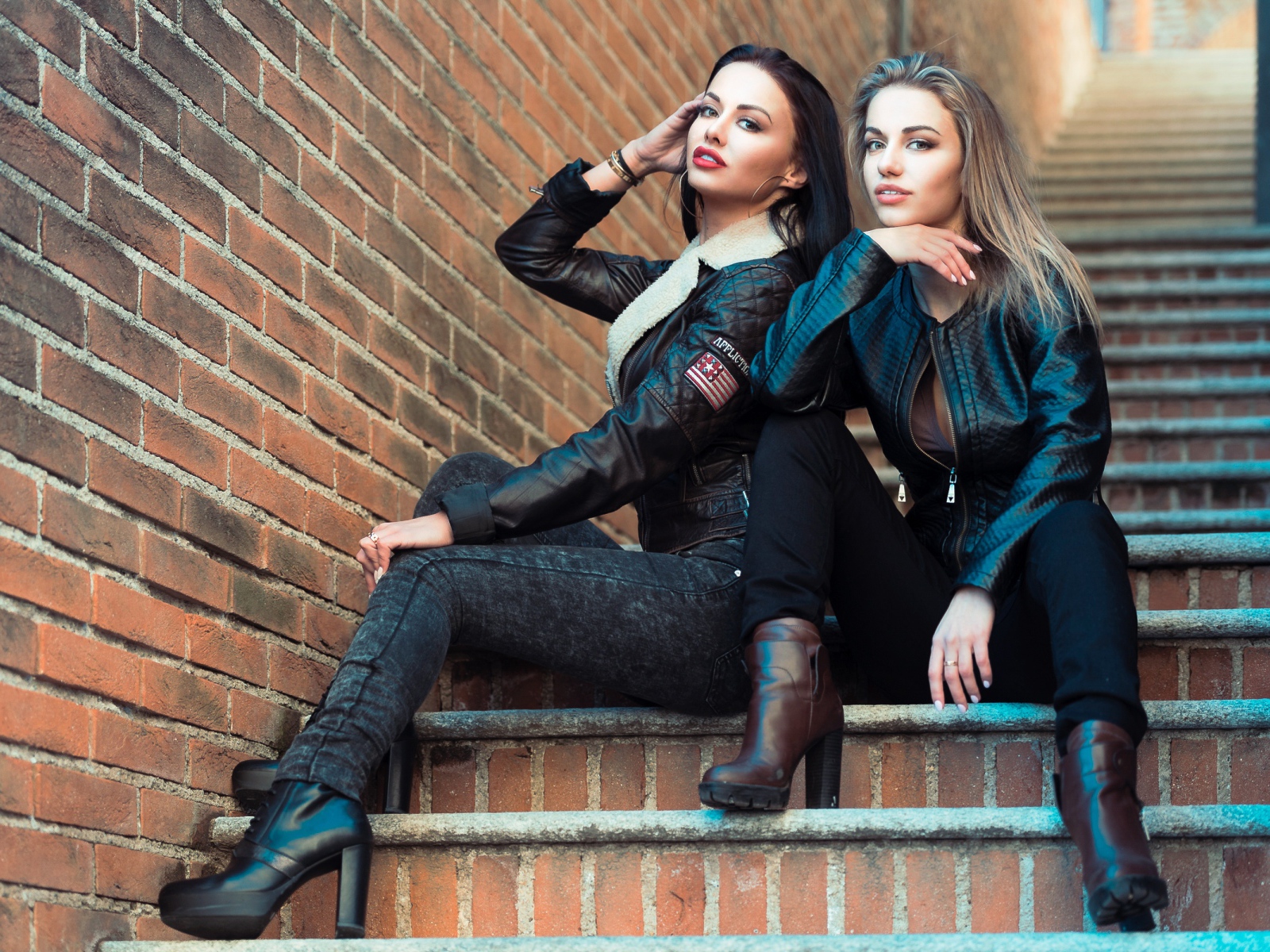 Две красивые девушки сидят на ступенях 