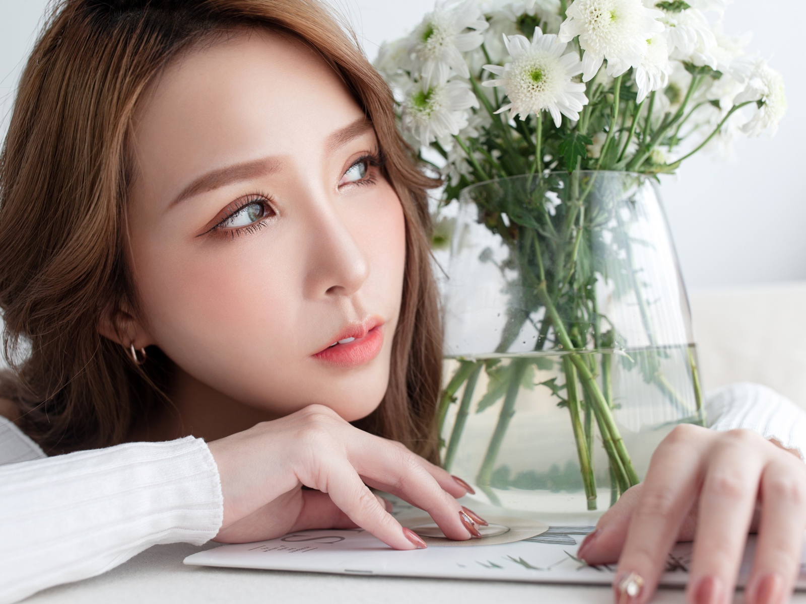 Молодая азиатка с букетом белой хризантемы в вазе