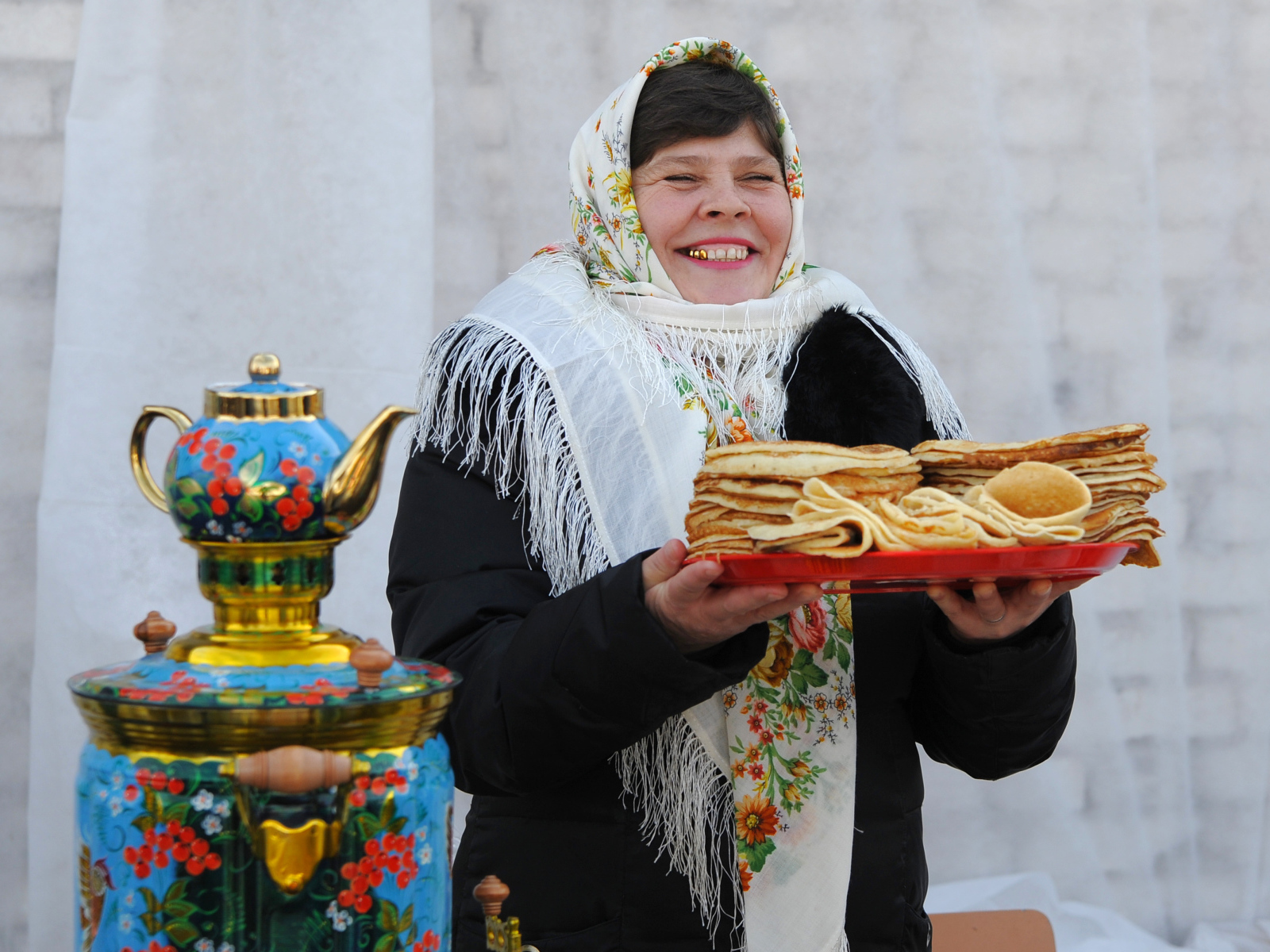 Женщина с блинами и самоваром на Масленицу