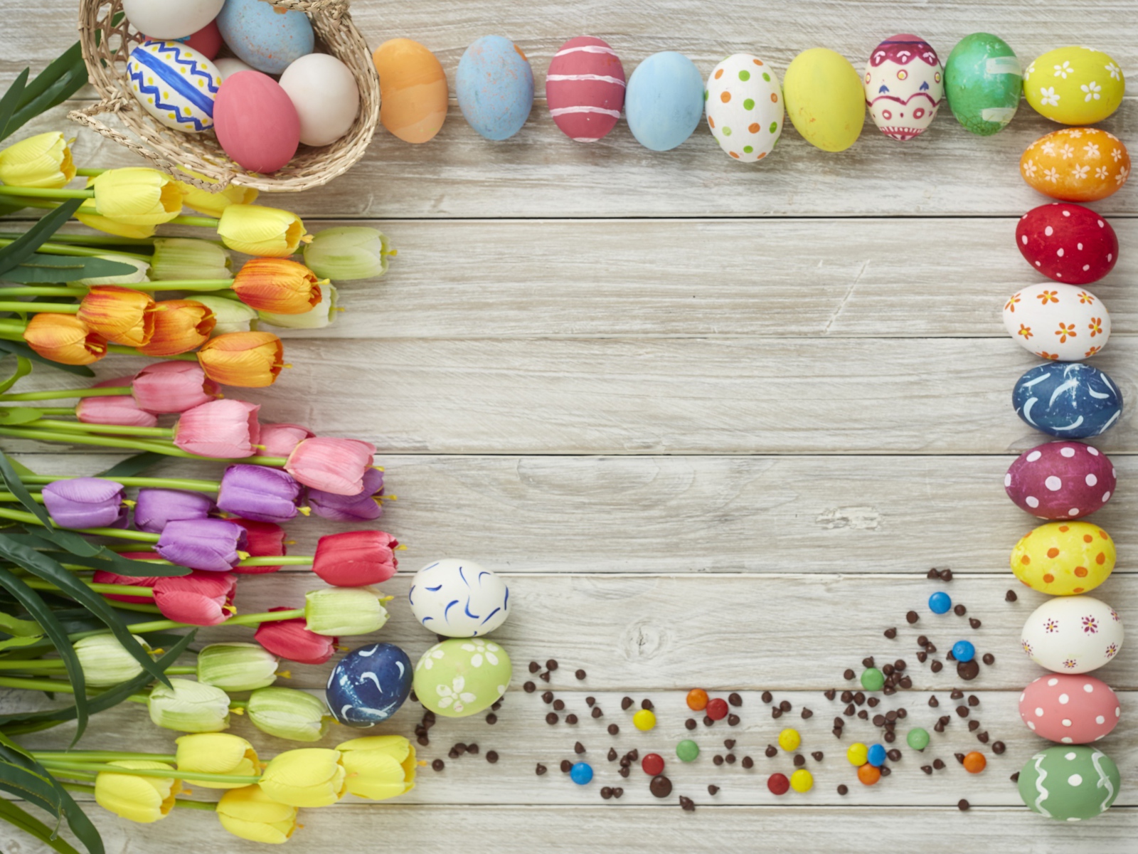 Красивые разноцветные пасхальные яйца с букетом тюльпанов