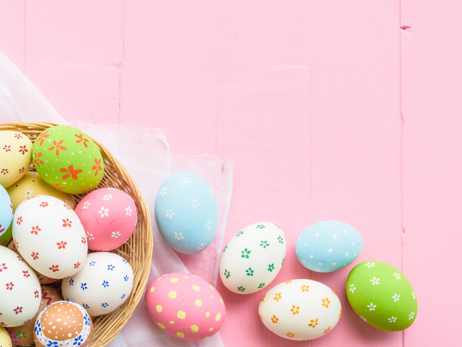 Разноцветные пасхальные яйца на розовом фоне