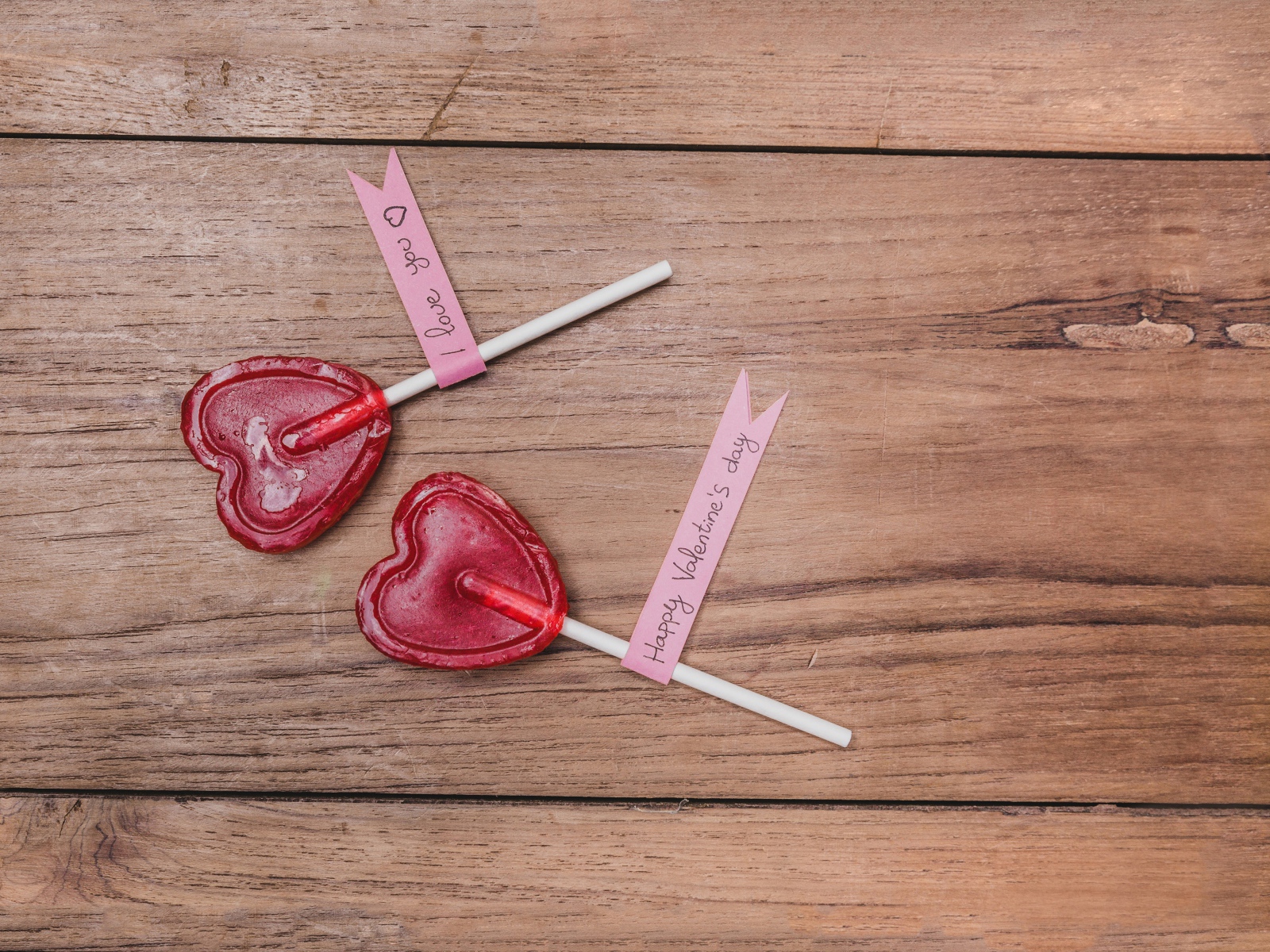 Два красных леденца для любимой на деревянном столе