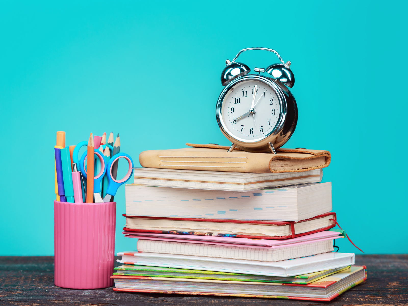 Будильник, книги и канцелярские предметы для школы