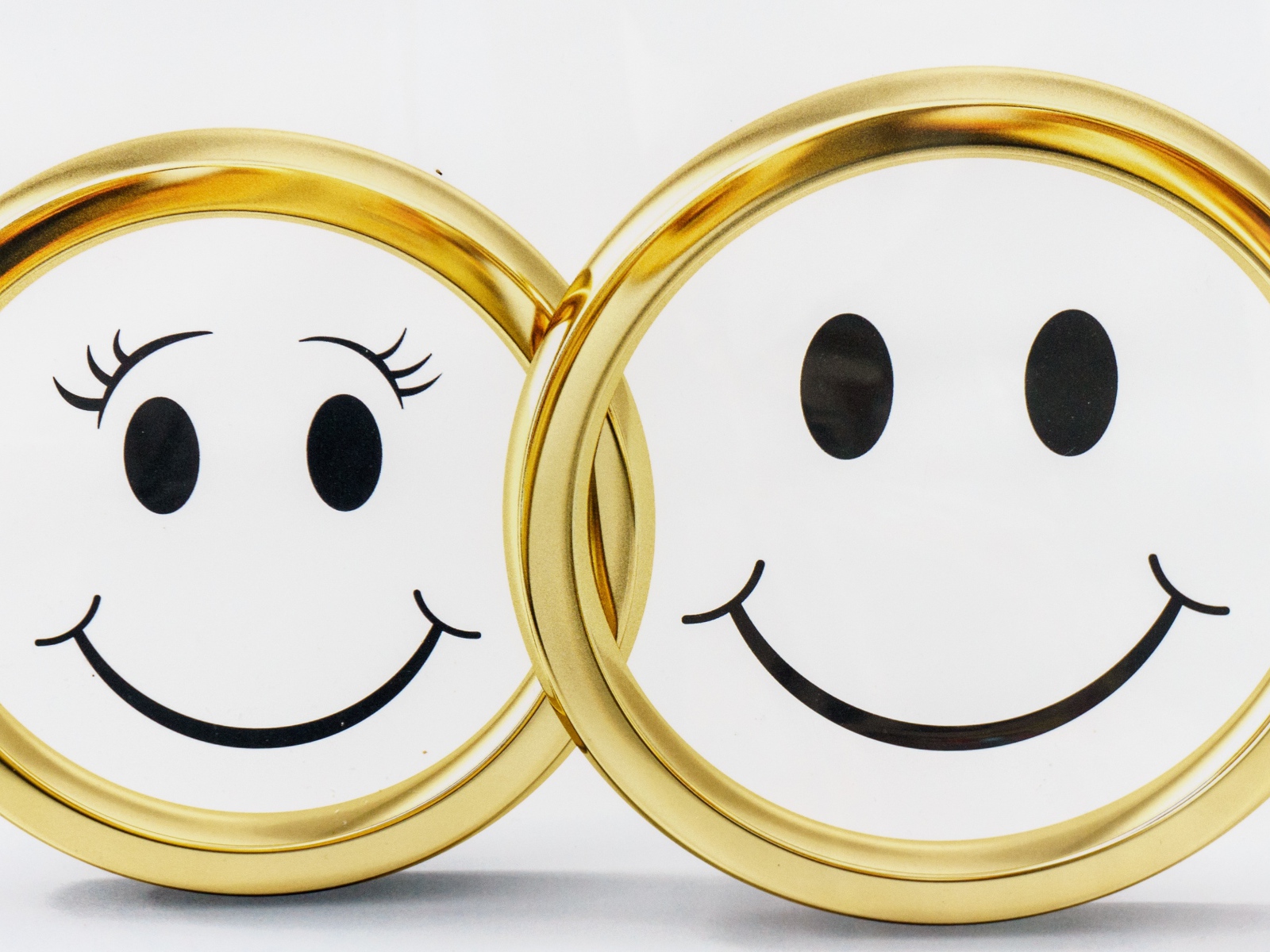 Золотые обручальные кольца на белом фоне