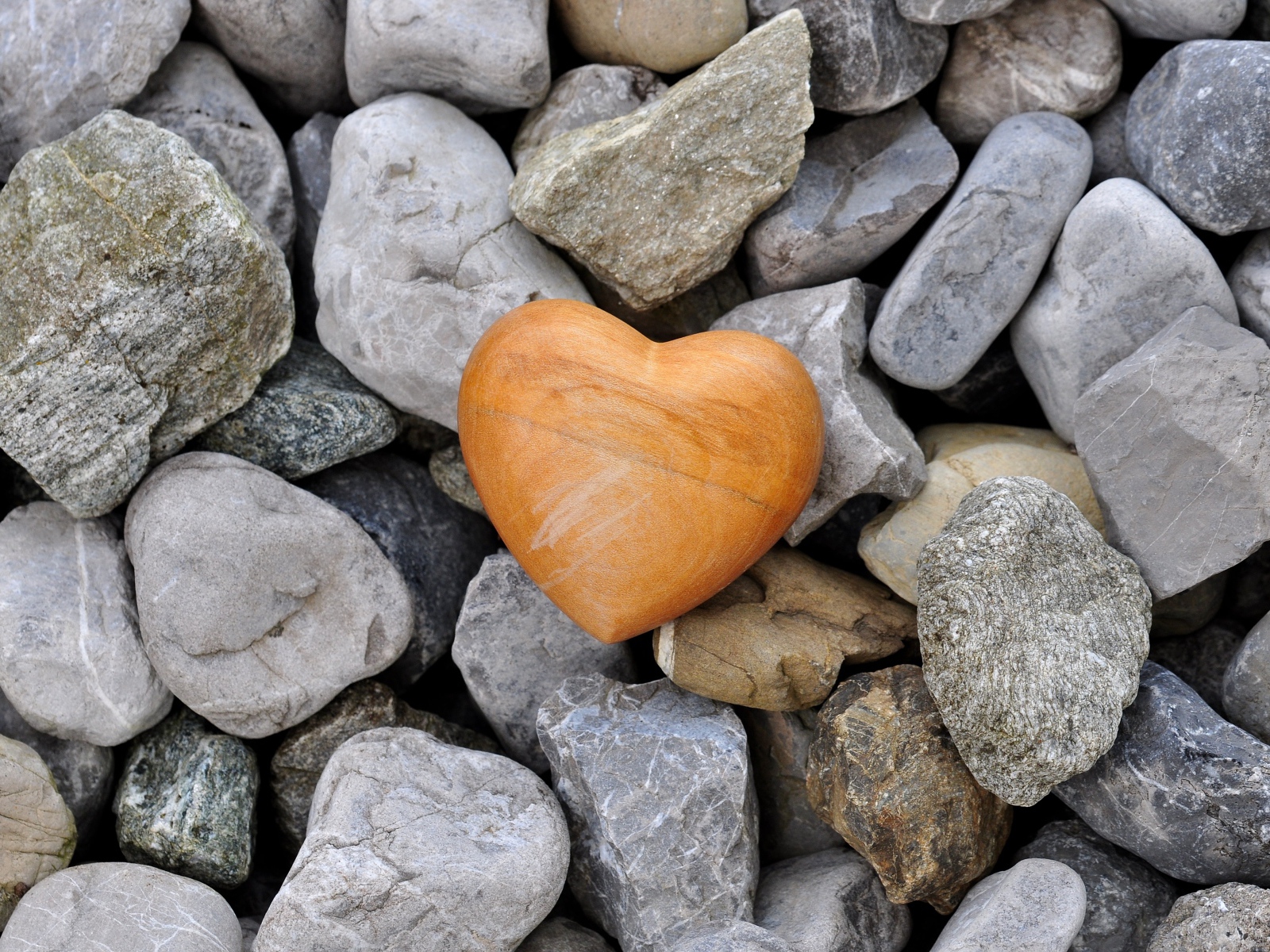 Каменное сердце лежит на камнях 