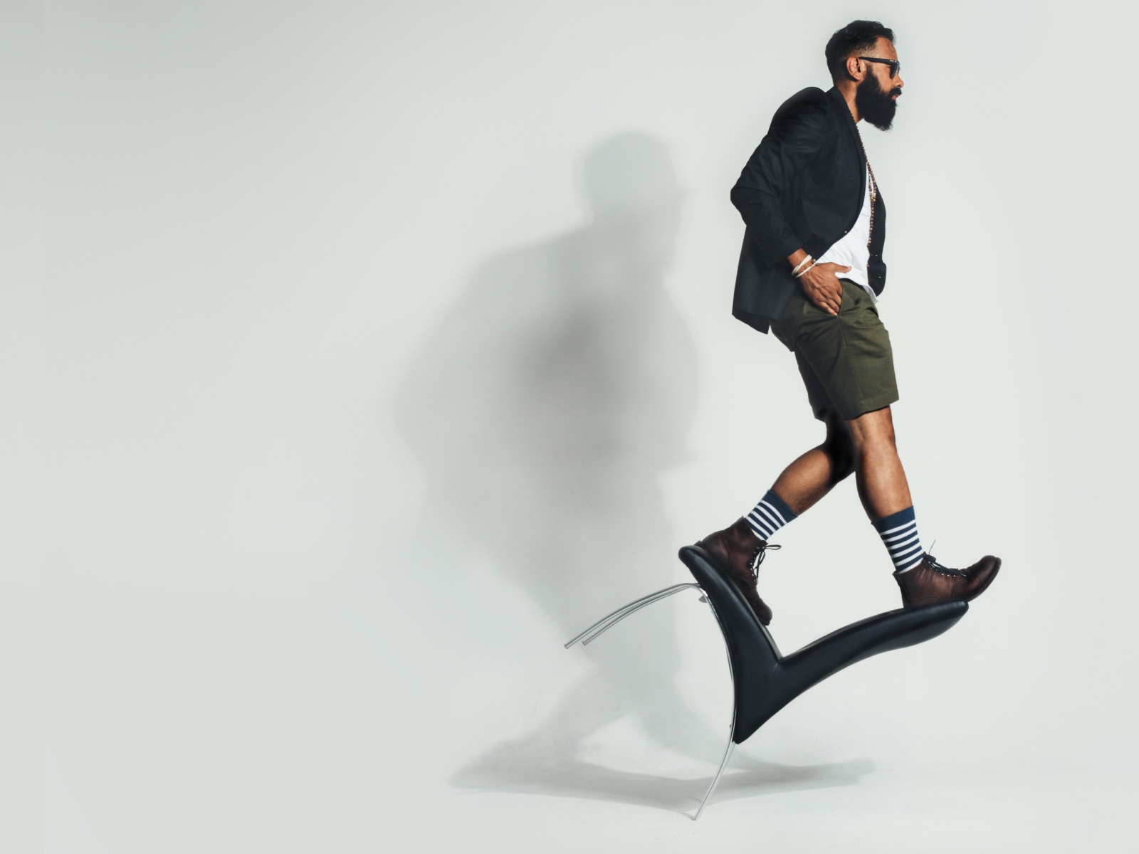 Мужчина балансирует на черном кресле